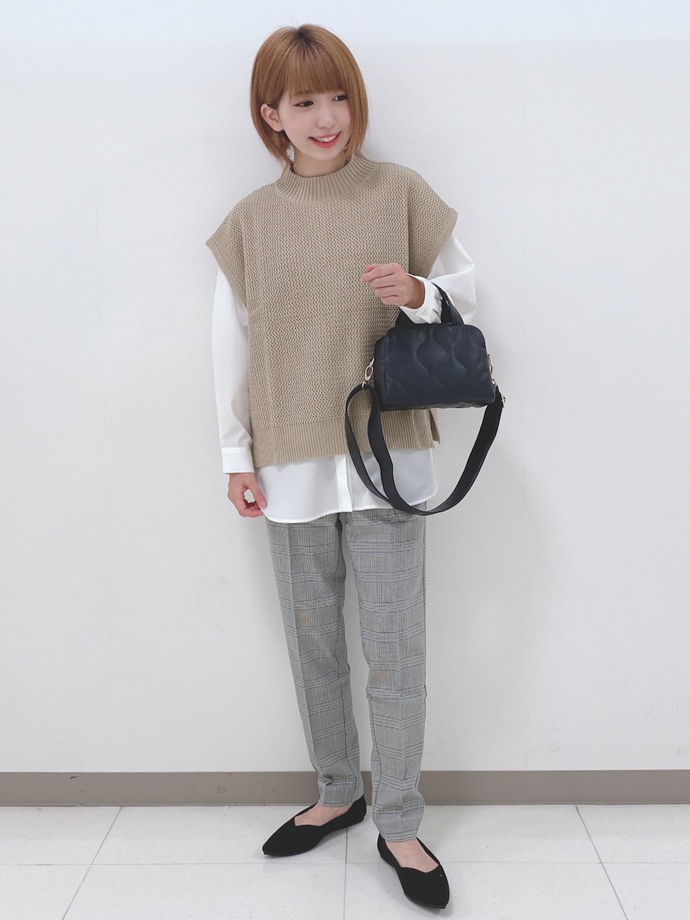 ベージュ系のベスト、ホワイト系のシャツ/ブラウス、ブラック系のパンプスを着用したレディースの秋コーディネートの4枚目の写真