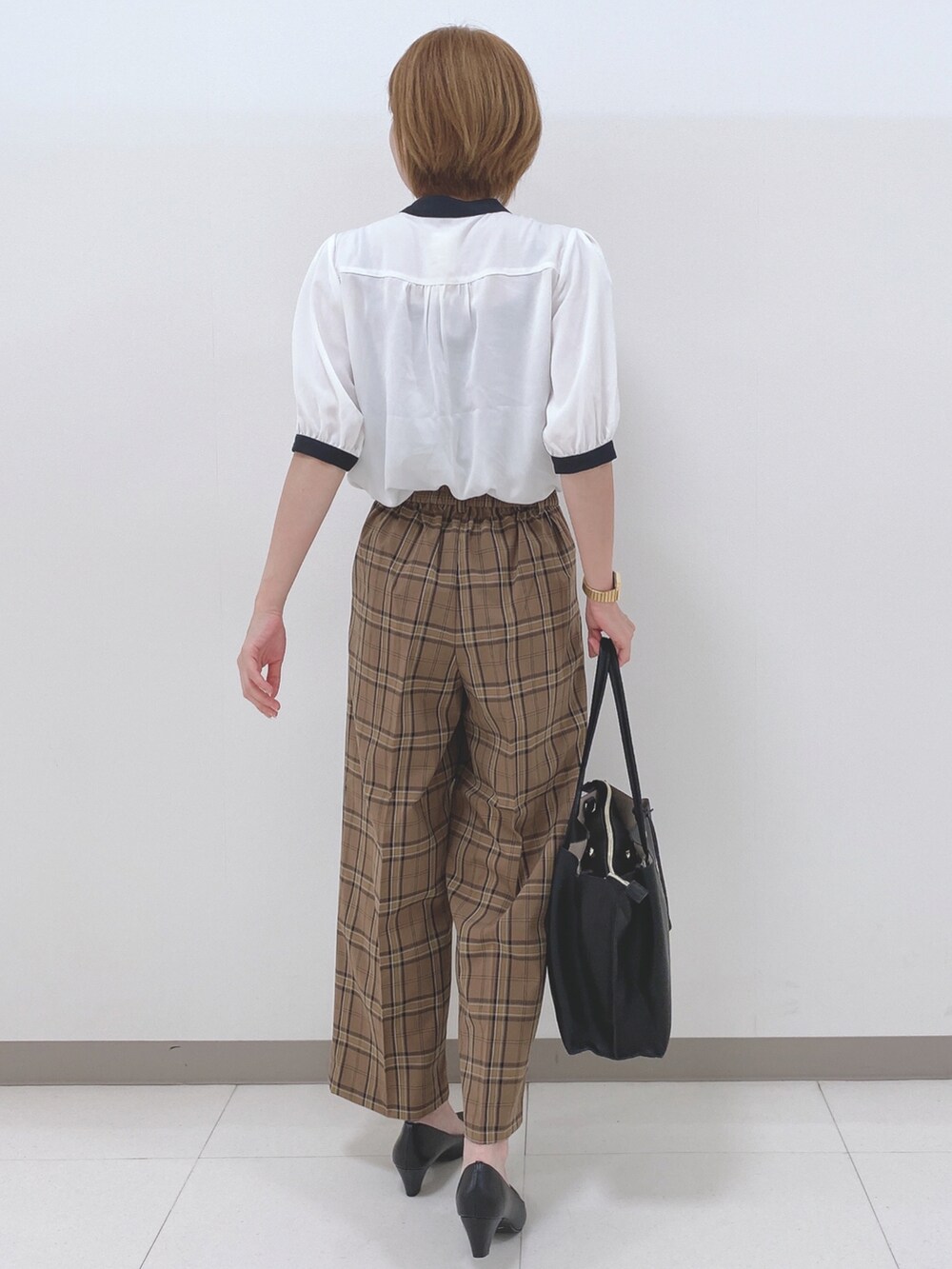 ホワイト系のシャツ/ブラウス、ベージュ系のパンツ、ブラック系のパンプスを着用したレディースの夏コーディネートの3枚目の写真