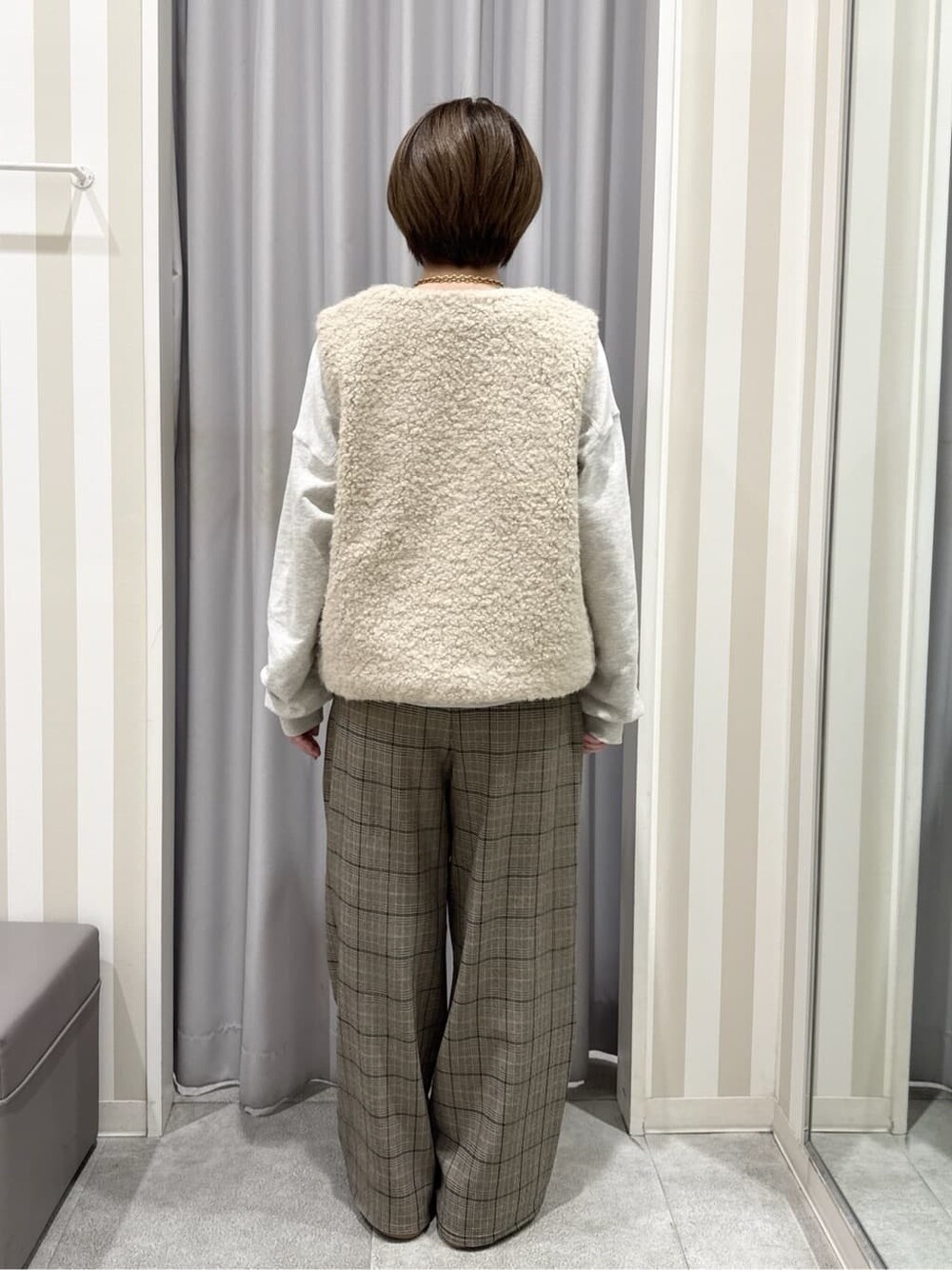 ベージュ系のベスト、ホワイト系のスウェット、ベージュ系のその他パンツを着用したレディースの秋コーディネートの3枚目の写真