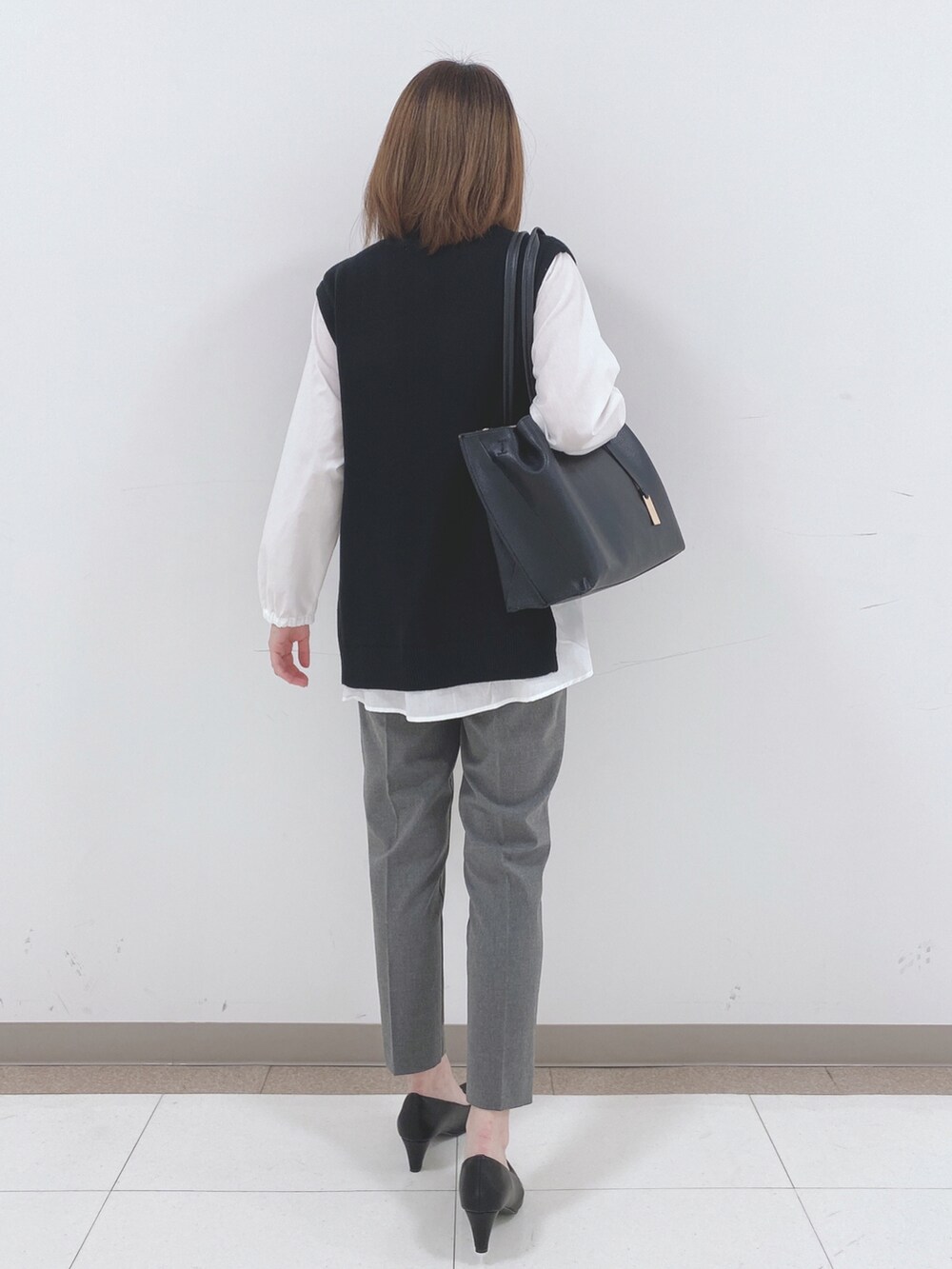 ブラック系のTシャツ/カットソー、グレー系のその他パンツ、ブラック系のパンプスを着用したレディースの冬コーディネートの3枚目の写真