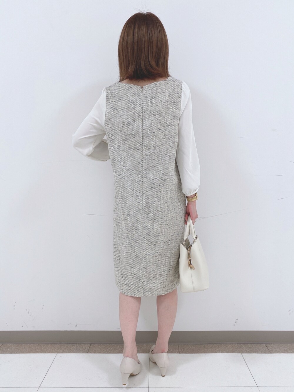 グレー系のワンピース、ベージュ系のパンプス、ホワイト系のトートバッグを着用したレディースの春コーディネートの3枚目の写真