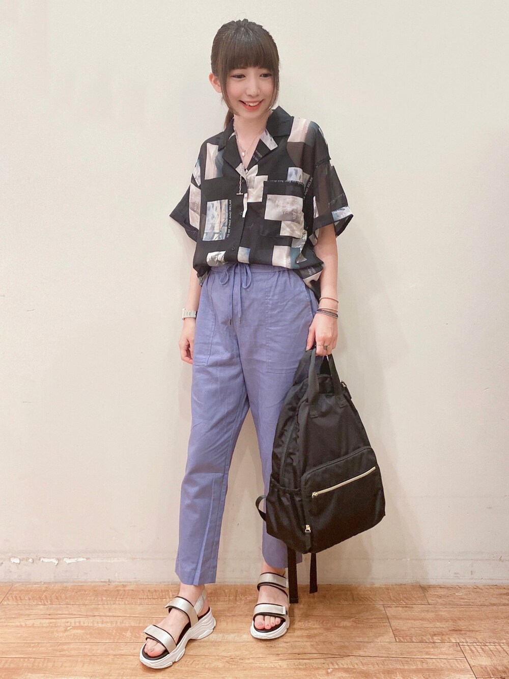 ブルー系のその他パンツ、ベージュ系のサンダル、ブラック系のバックパック/リュックを着用したレディースの春コーディネートの4枚目の写真