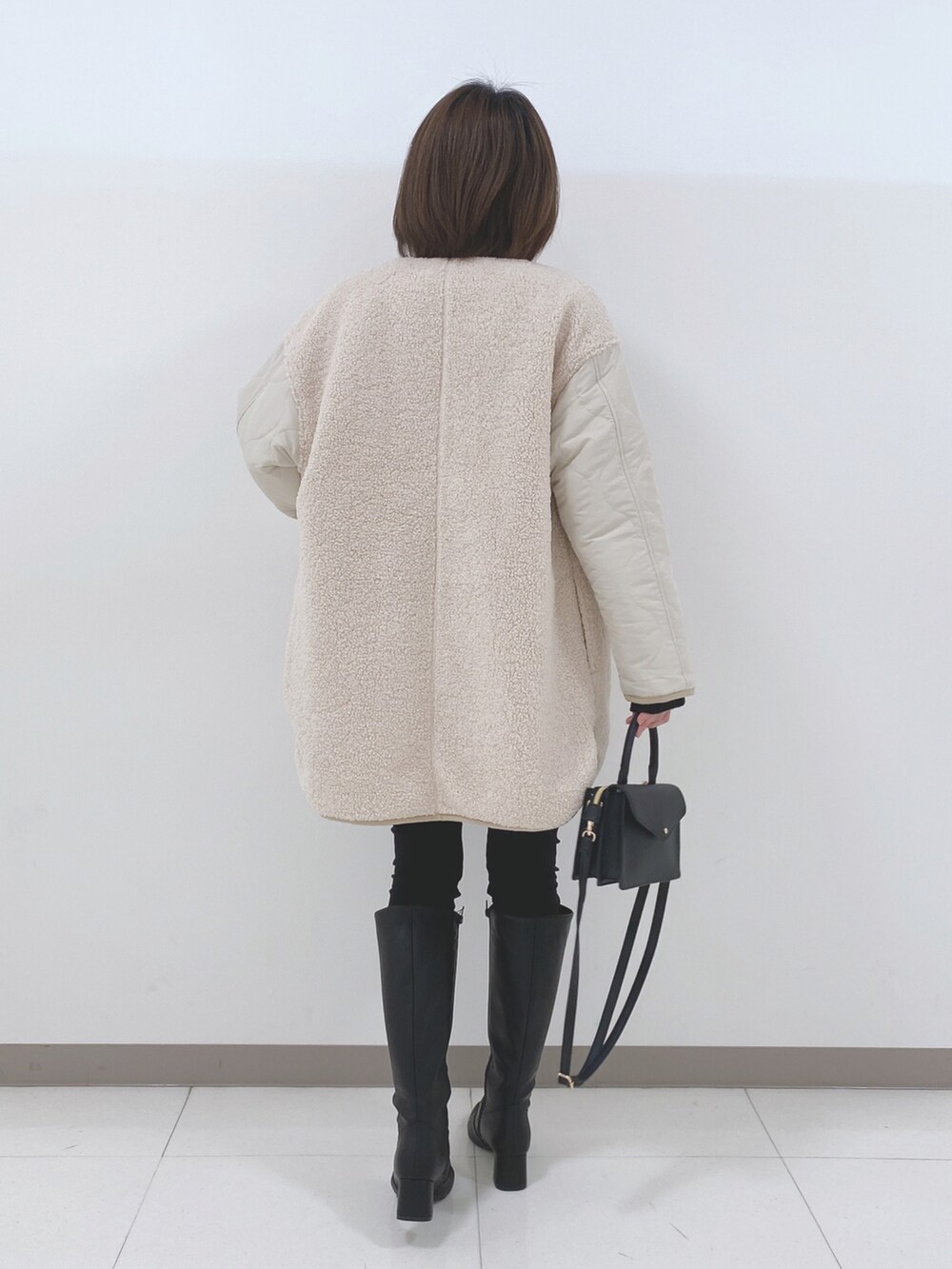 ベージュ系のノーカラージャケット、ブラック系のニット/セーター、ブラック系のその他パンツを着用したレディースの冬コーディネートの3枚目の写真