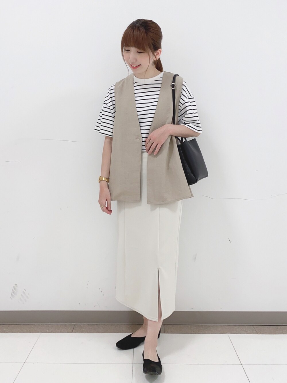 ベージュ系のベスト、ホワイト系のTシャツ/カットソー、ホワイト系のスカートを着用したレディースの春コーディネートの4枚目の写真