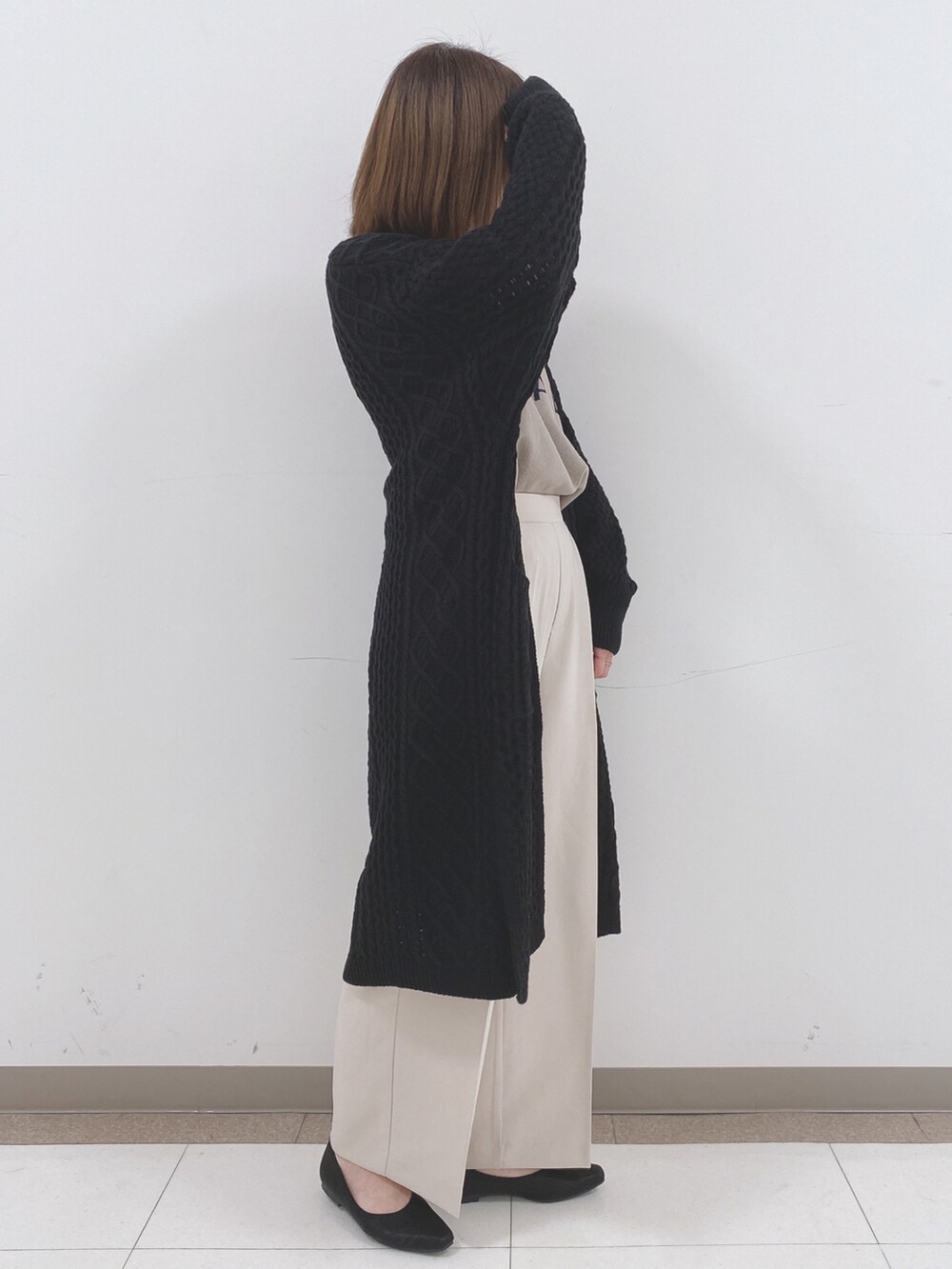 ベージュ系のニット/セーター、ベージュ系のその他パンツ、ブラック系のTシャツ/カットソーを着用したレディースの冬コーディネートの2枚目の写真