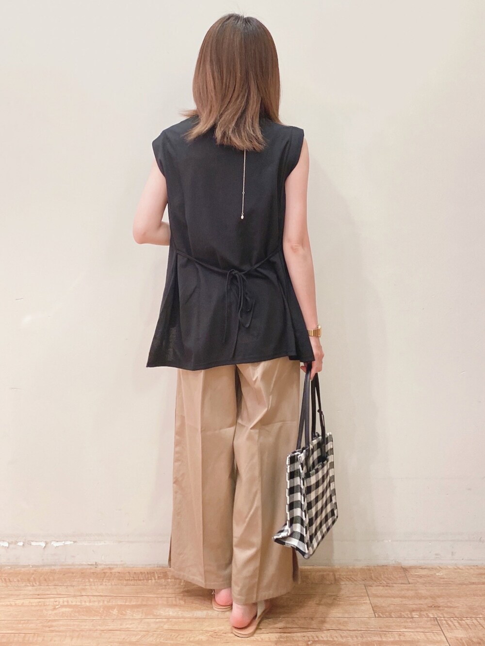 ブラック系のTシャツ/カットソー、ベージュ系のその他パンツ、ホワイト系のサンダルを着用したレディースの夏コーディネートの3枚目の写真