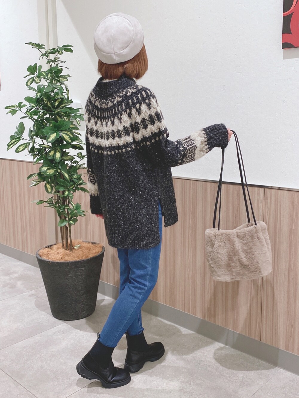 グレー系のニット/セーター、ブルー系のデニムパンツ、ブラック系のブーツを着用したレディースの冬コーディネートの2枚目の写真