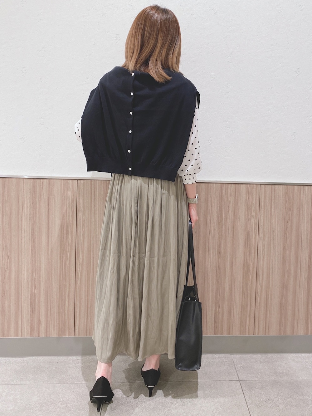 ホワイト系のシャツ/ブラウス、ブラック系のカーディガン/ボレロ、グリーン系のスカートを着用したレディースの春コーディネートの3枚目の写真