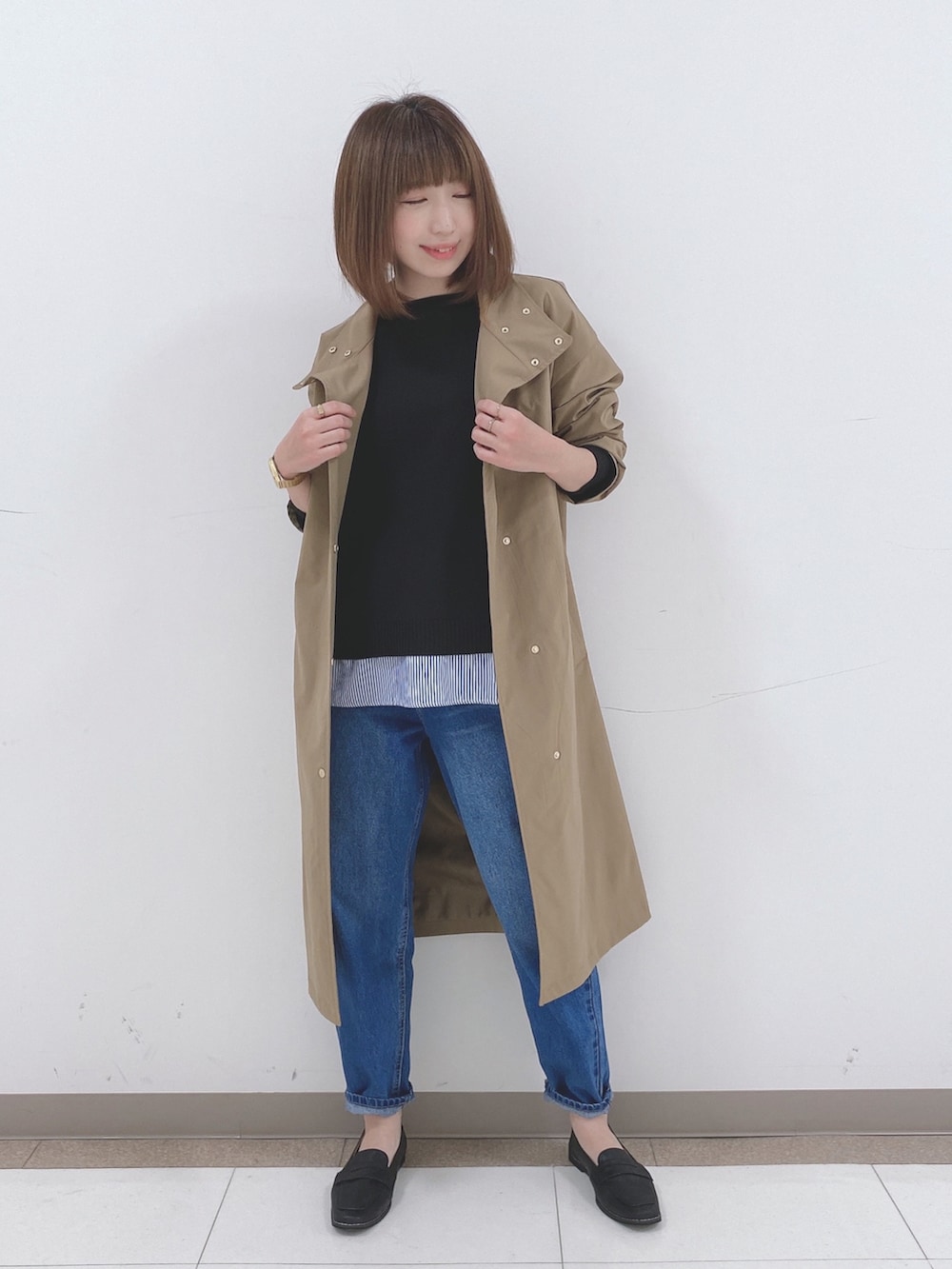 ブラック系のニット/セーター、ベージュ系のその他アウター、ブルー系のデニムパンツを着用したレディースの冬コーディネートの4枚目の写真