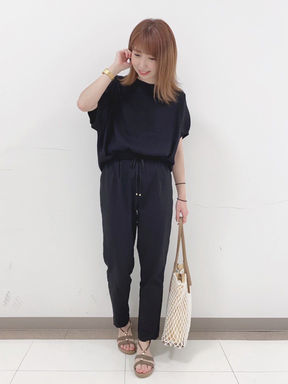 ブラック系のその他パンツ、ベージュ系のサンダル、ホワイト系のトートバッグを着用したレディースの春コーディネートの4枚目の写真