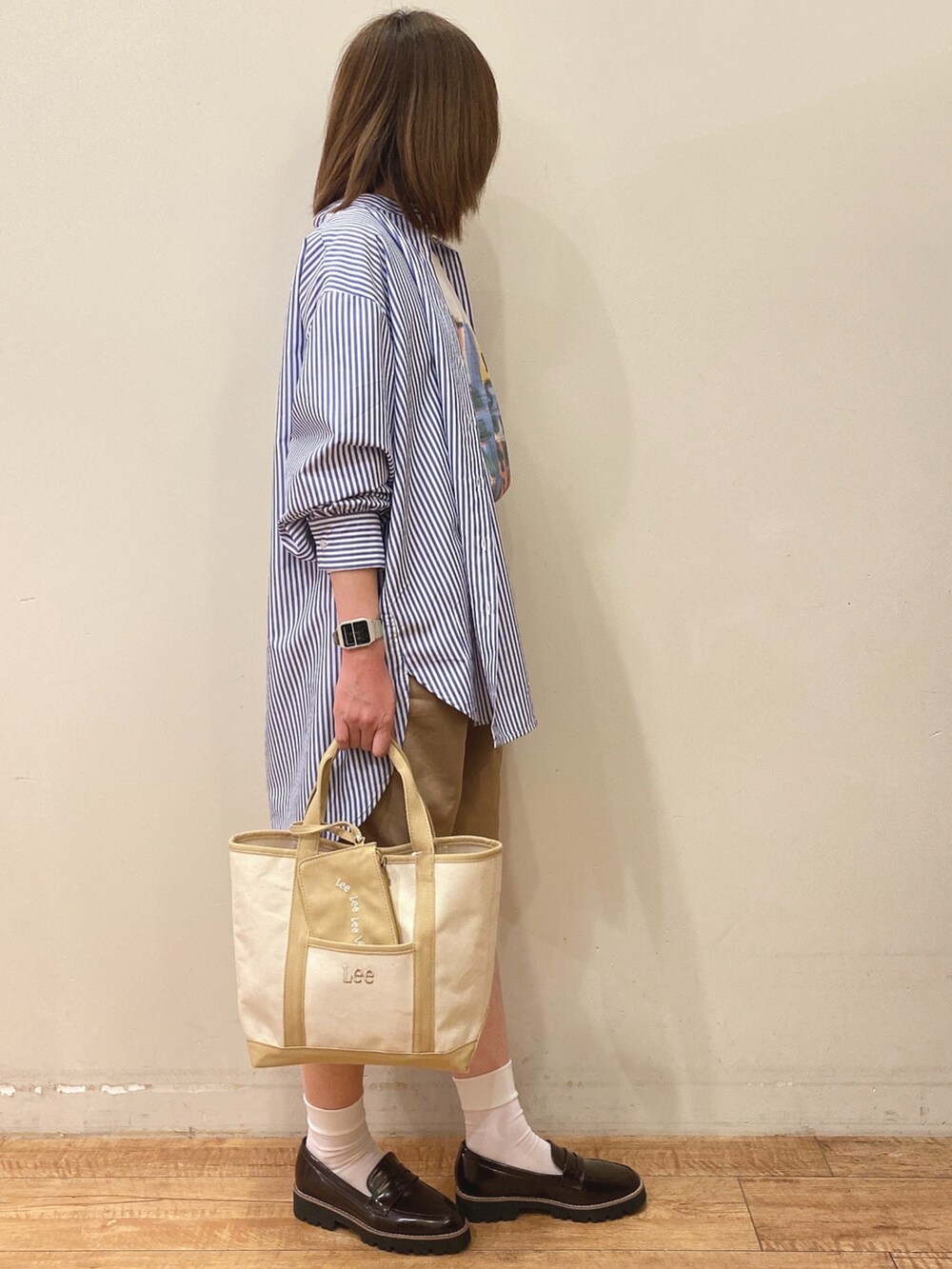 ブルー系のワンピース、ベージュ系のトートバッグ、ブラウン系のその他シューズを着用したレディースの春コーディネートの2枚目の写真