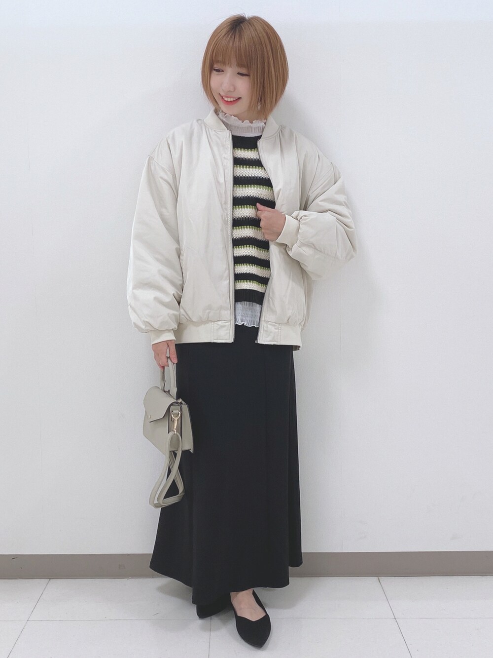 ベージュ系のブルゾン、ブラック系のニット/セーター、ホワイト系のTシャツ/カットソーを着用したレディースの秋コーディネートの4枚目の写真
