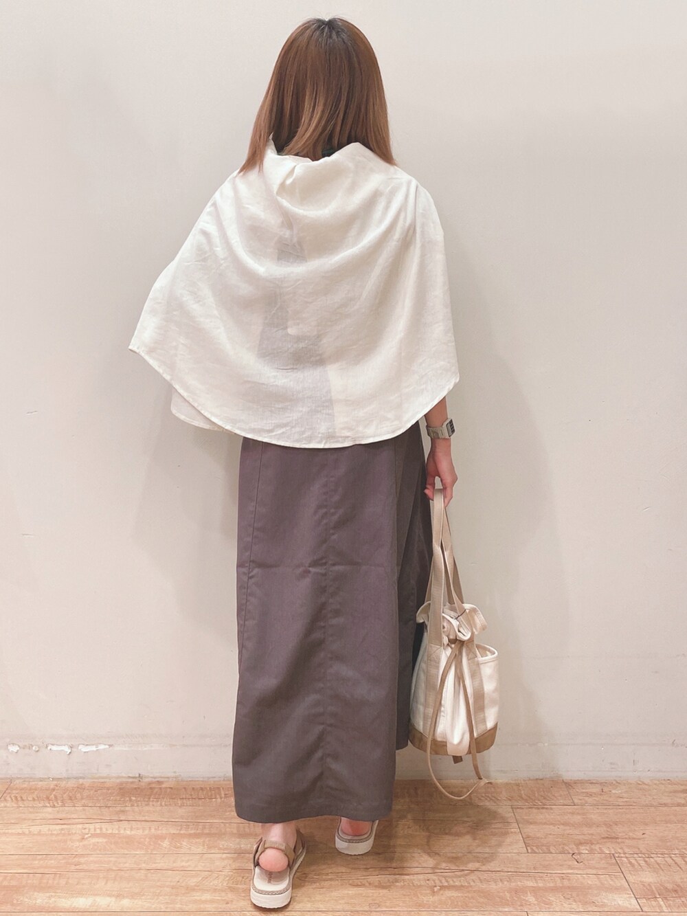 ブルー系のTシャツ/カットソー、ホワイト系のシャツ/ブラウス、グレー系のスカートを着用したレディースの春コーディネートの3枚目の写真