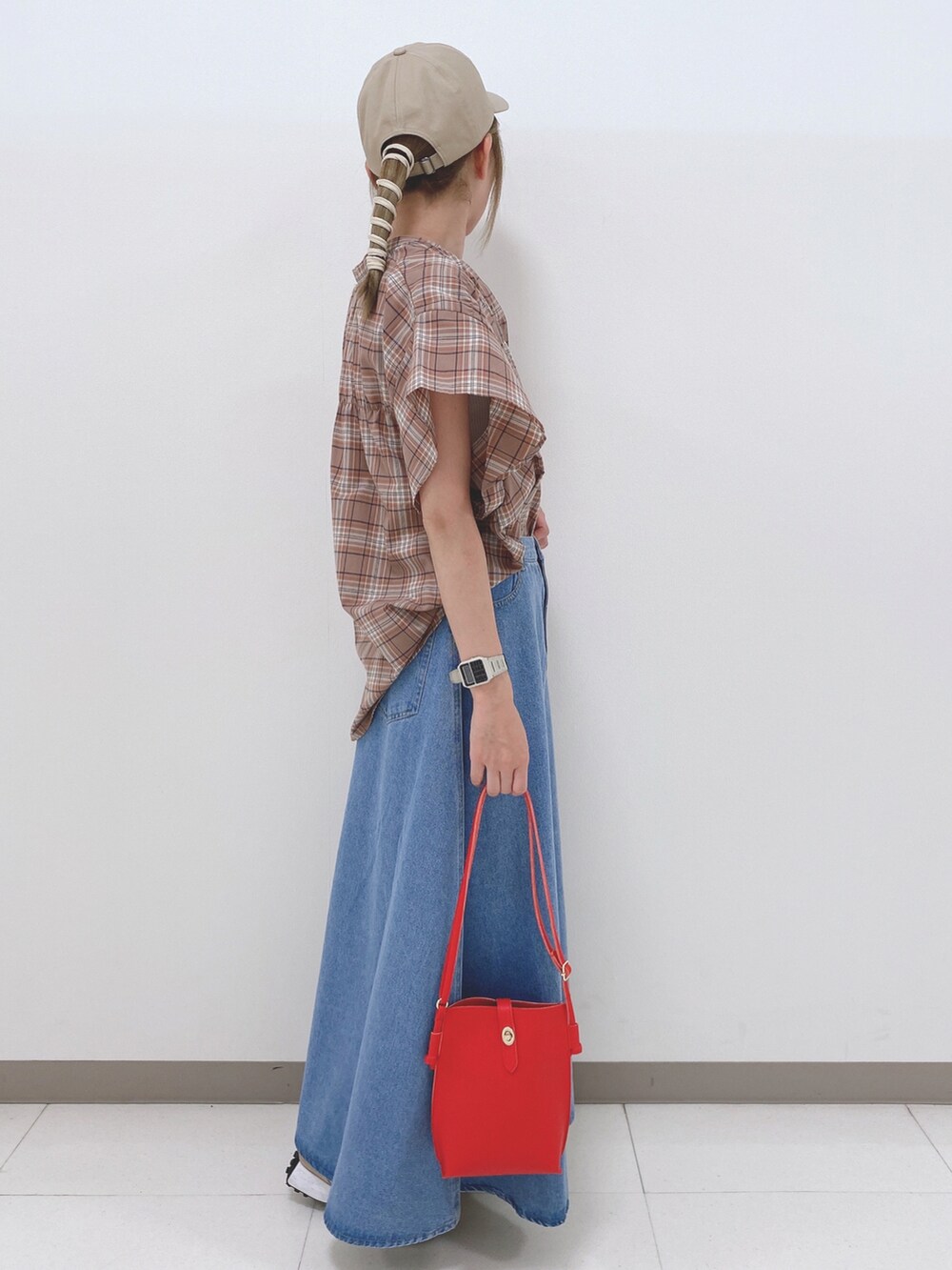 ベージュ系のシャツ/ブラウス、ブルー系のスカート、ベージュ系のスニーカーを着用したレディースの夏コーディネートの3枚目の写真