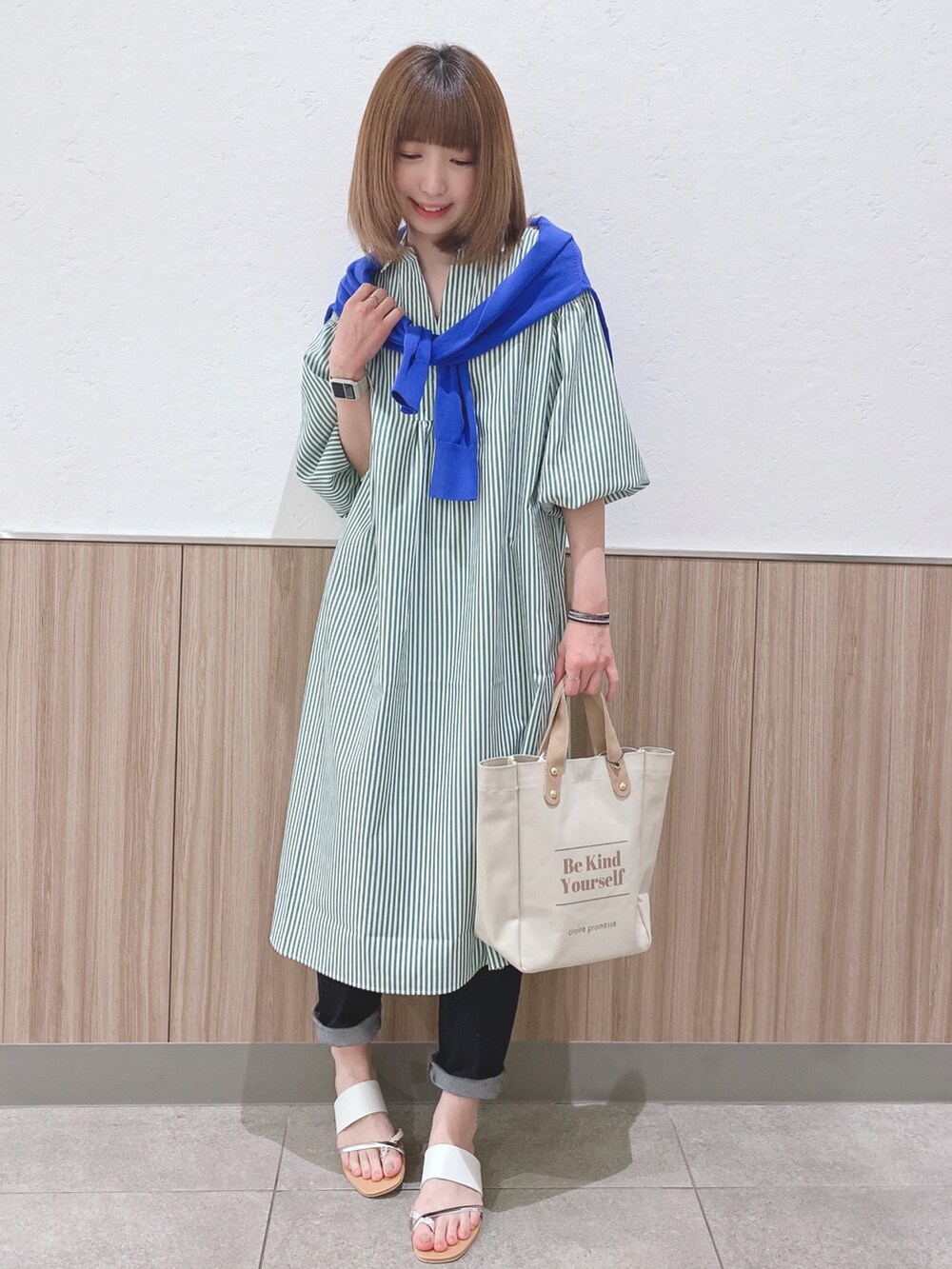 グリーン系のワンピース、ブルー系のカーディガン/ボレロ、ベージュ系のトートバッグを着用したレディースの春コーディネートの4枚目の写真