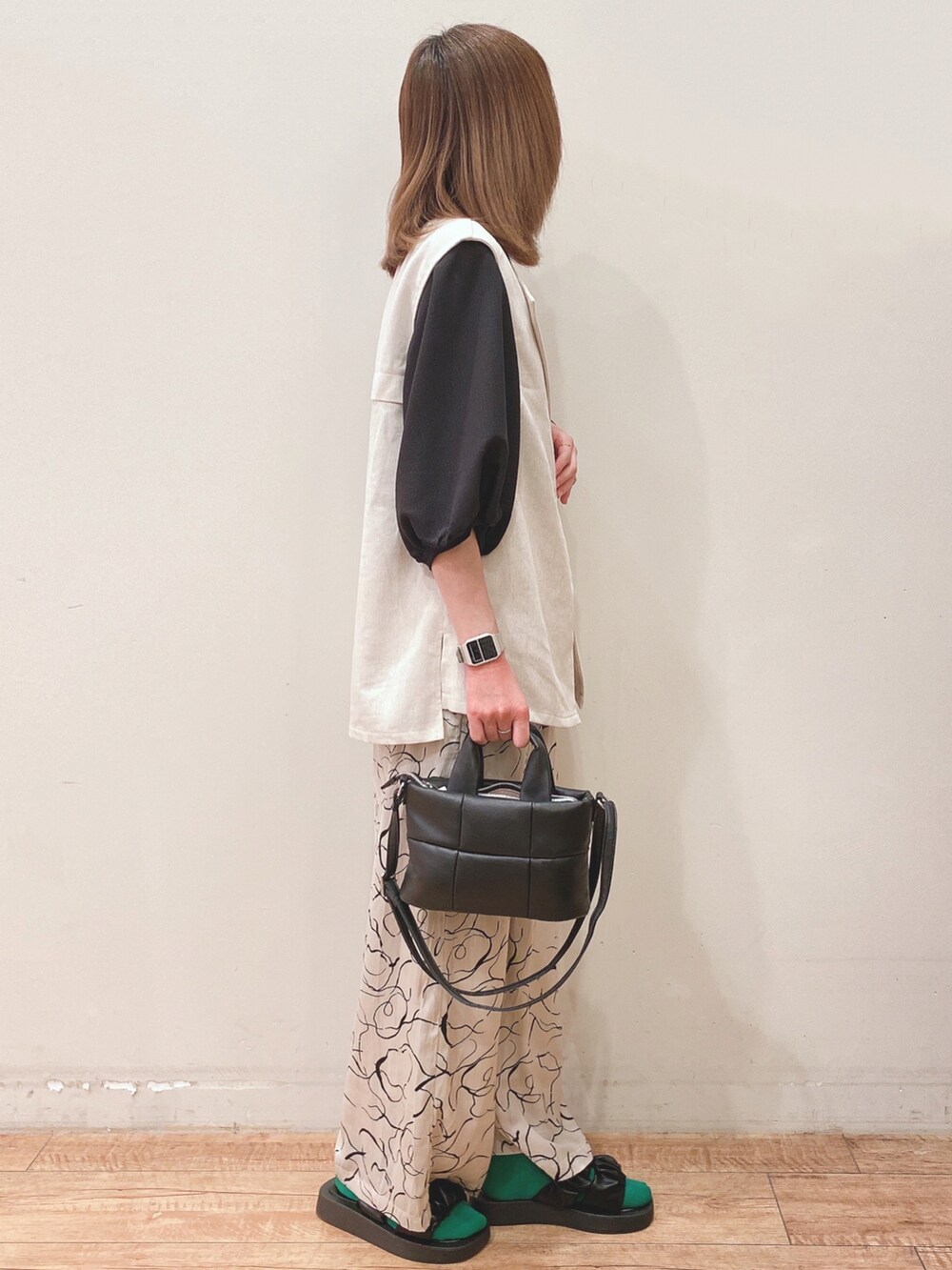 ベージュ系のベスト、ベージュ系のその他パンツ、ブラック系のショルダーバッグを着用したレディースの春コーディネートの2枚目の写真