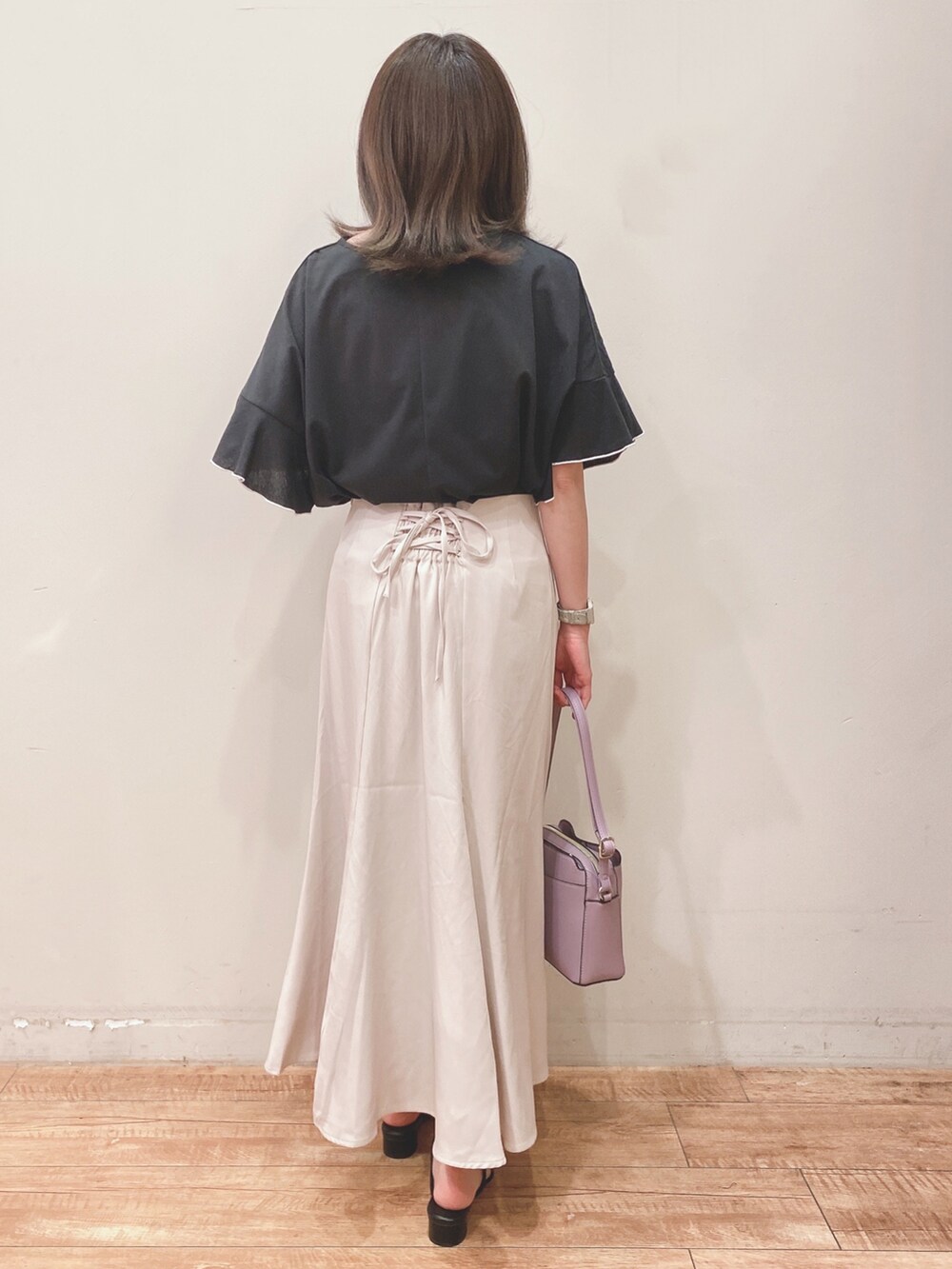 ブラック系のTシャツ/カットソー、ブラック系のサンダル、パープル系のショルダーバッグを着用したレディースの春コーディネートの3枚目の写真