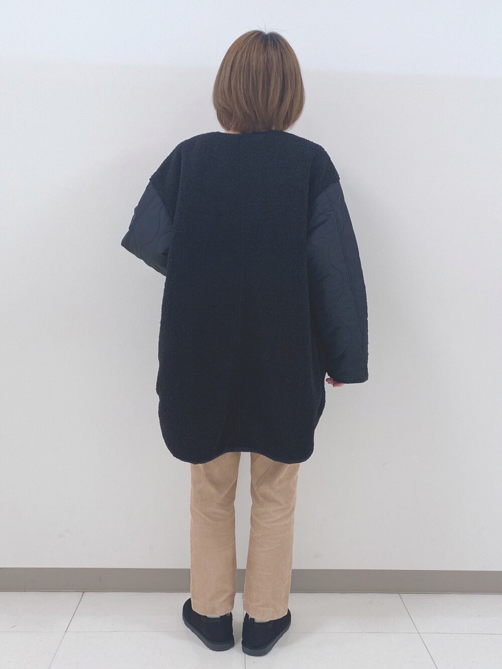 ブラック系のノーカラージャケット、ホワイト系のニット/セーター、イエロー系のその他パンツを着用したレディースの秋コーディネートの3枚目の写真