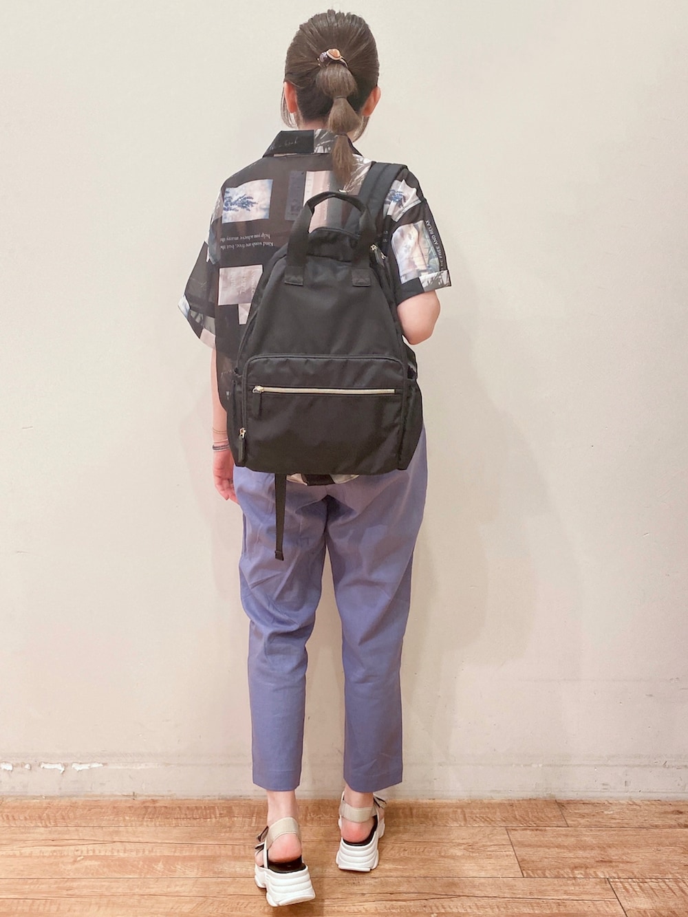 ブルー系のその他パンツ、ベージュ系のサンダル、ブラック系のバックパック/リュックを着用したレディースの春コーディネートの3枚目の写真