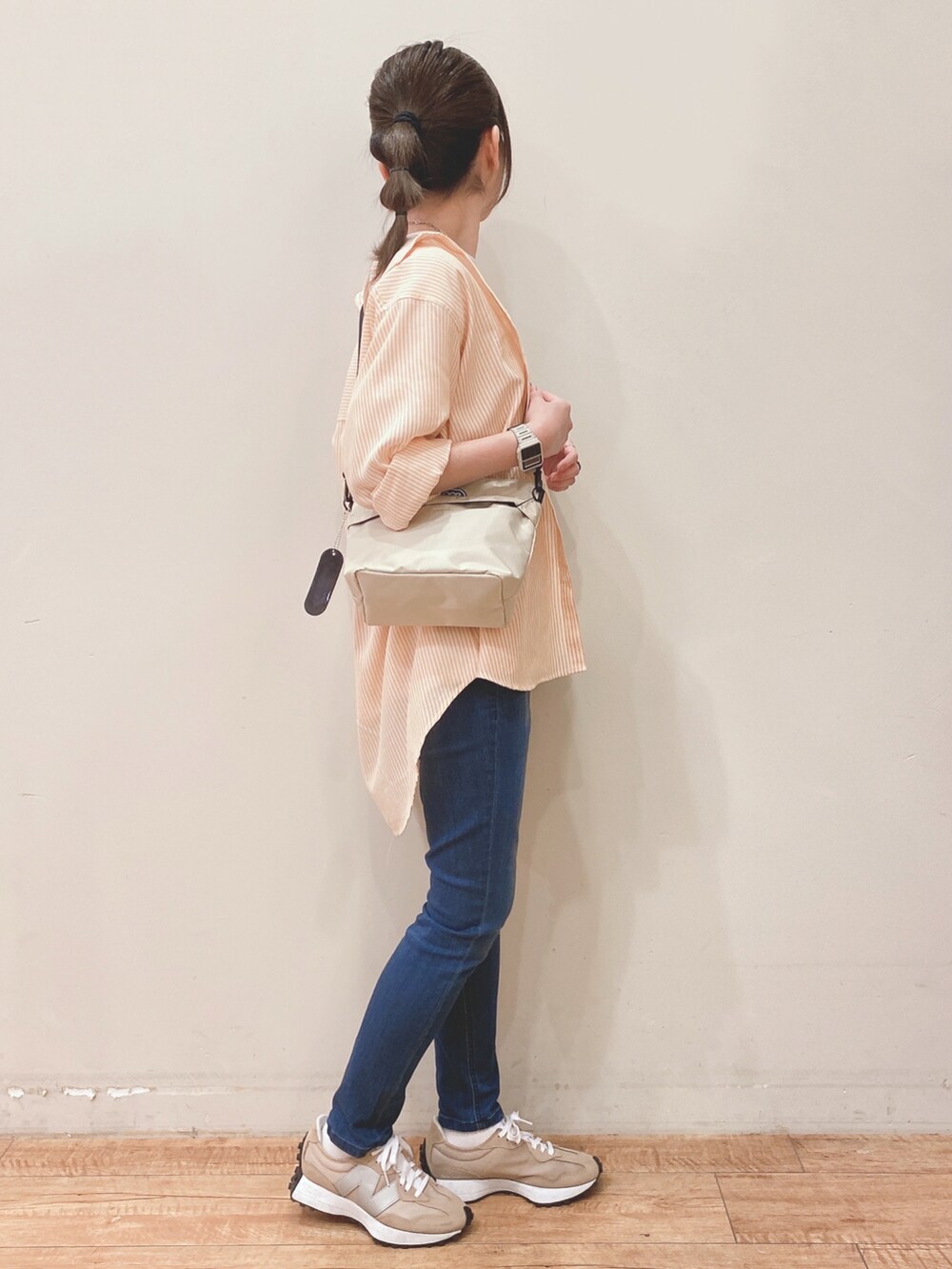 ホワイト系のTシャツ/カットソー、オレンジ系のシャツ/ブラウス、ベージュ系のショルダーバッグを着用したレディースの春コーディネートの2枚目の写真