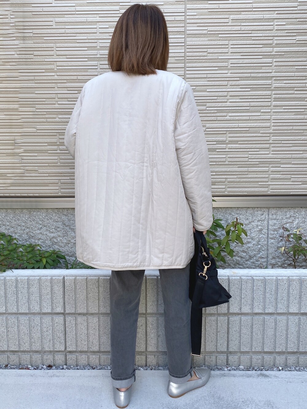 ベージュ系のTシャツ/カットソー、ホワイト系のその他アウター、ブラック系のトートバッグを着用したレディースの冬コーディネートの2枚目の写真