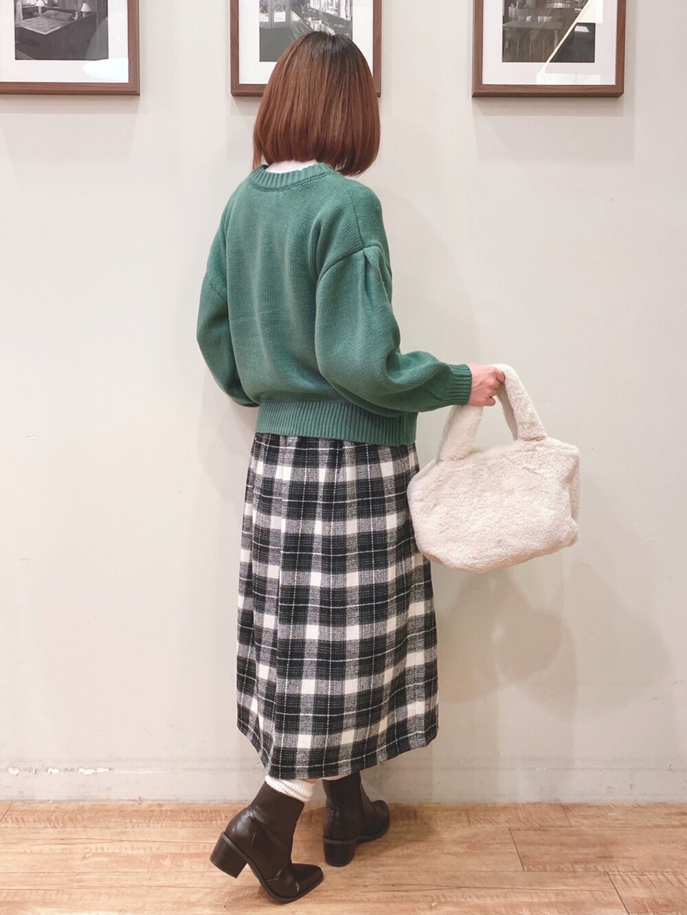 グリーン系のカーディガン/ボレロ、ホワイト系のトートバッグ、グレー系のスカートを着用したレディースの冬コーディネートの2枚目の写真