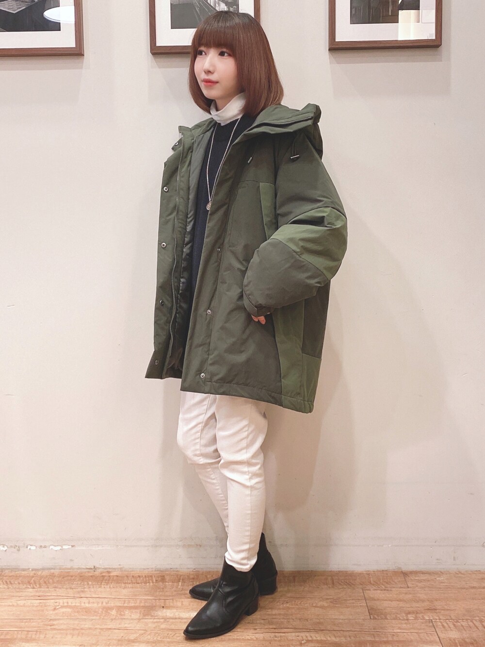 グリーン系のその他アウター、ブラック系のニット/セーター、ホワイト系のデニムパンツを着用したレディースの冬コーディネートの2枚目の写真