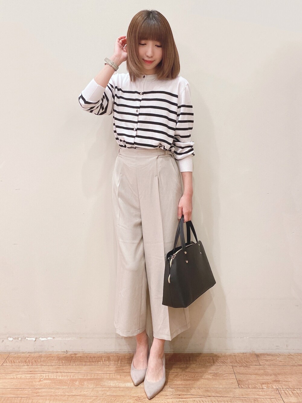 ホワイト系のカーディガン/ボレロ、ベージュ系のその他パンツ、ブラック系のトートバッグを着用したレディースの春コーディネートの4枚目の写真