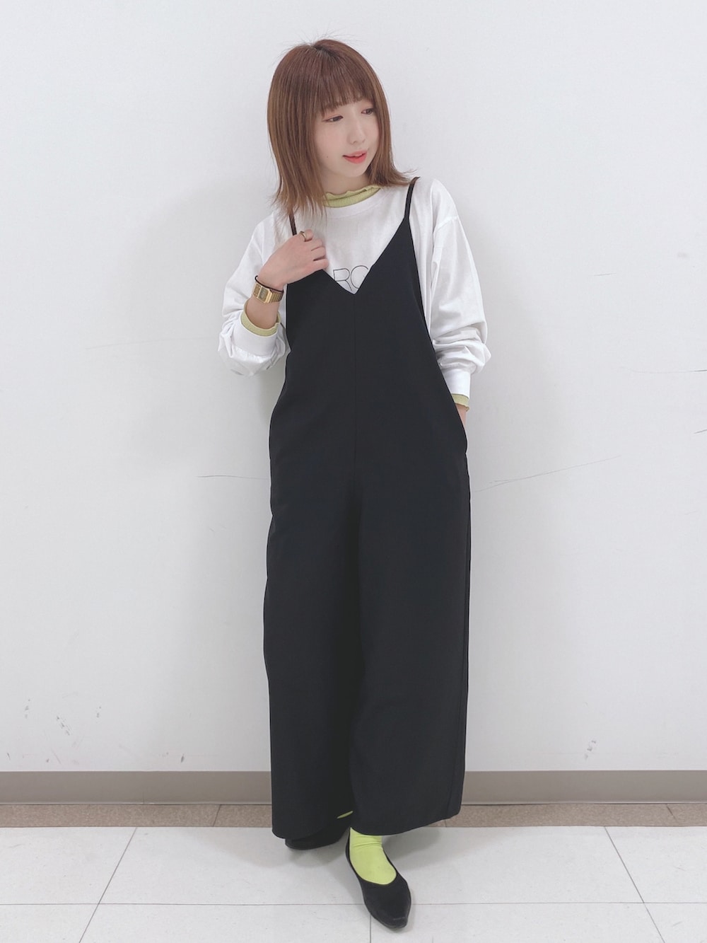 ホワイト系のTシャツ/カットソー、イエロー系のTシャツ/カットソー、ブラック系のサロペット/オーバーオールを着用したレディースの春コーディネートの4枚目の写真
