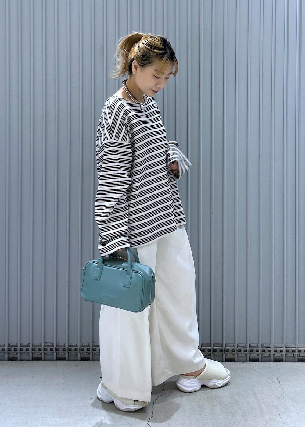 ホワイト系のサンダル、ホワイト系のその他パンツ、ブルー系のボストンバッグを着用したレディースの春コーディネートの3枚目の写真