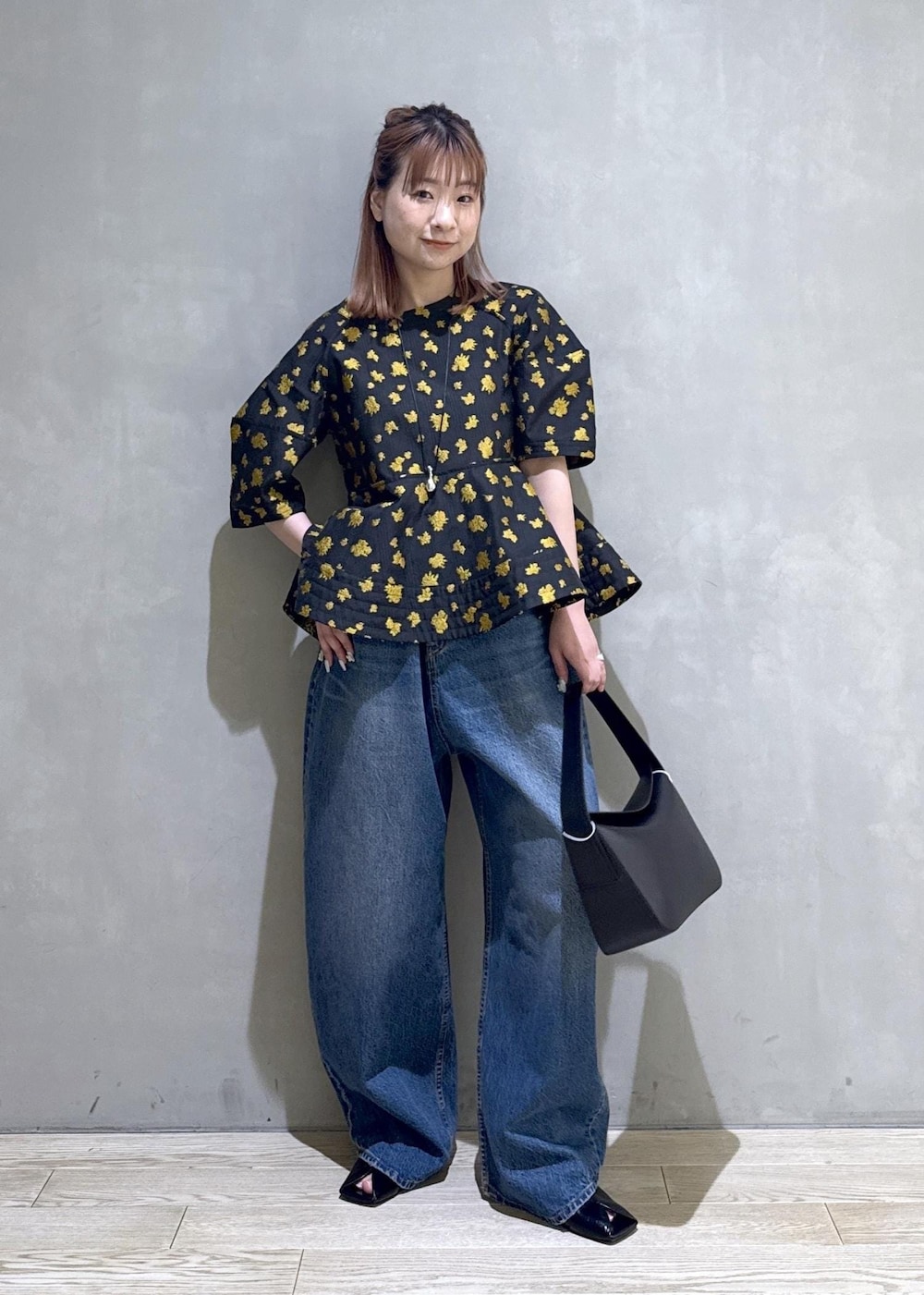 ブルー系のデニムパンツ、ブラック系のサンダル、ブラック系のショルダーバッグを着用したレディースの冬コーディネートの8枚目の写真