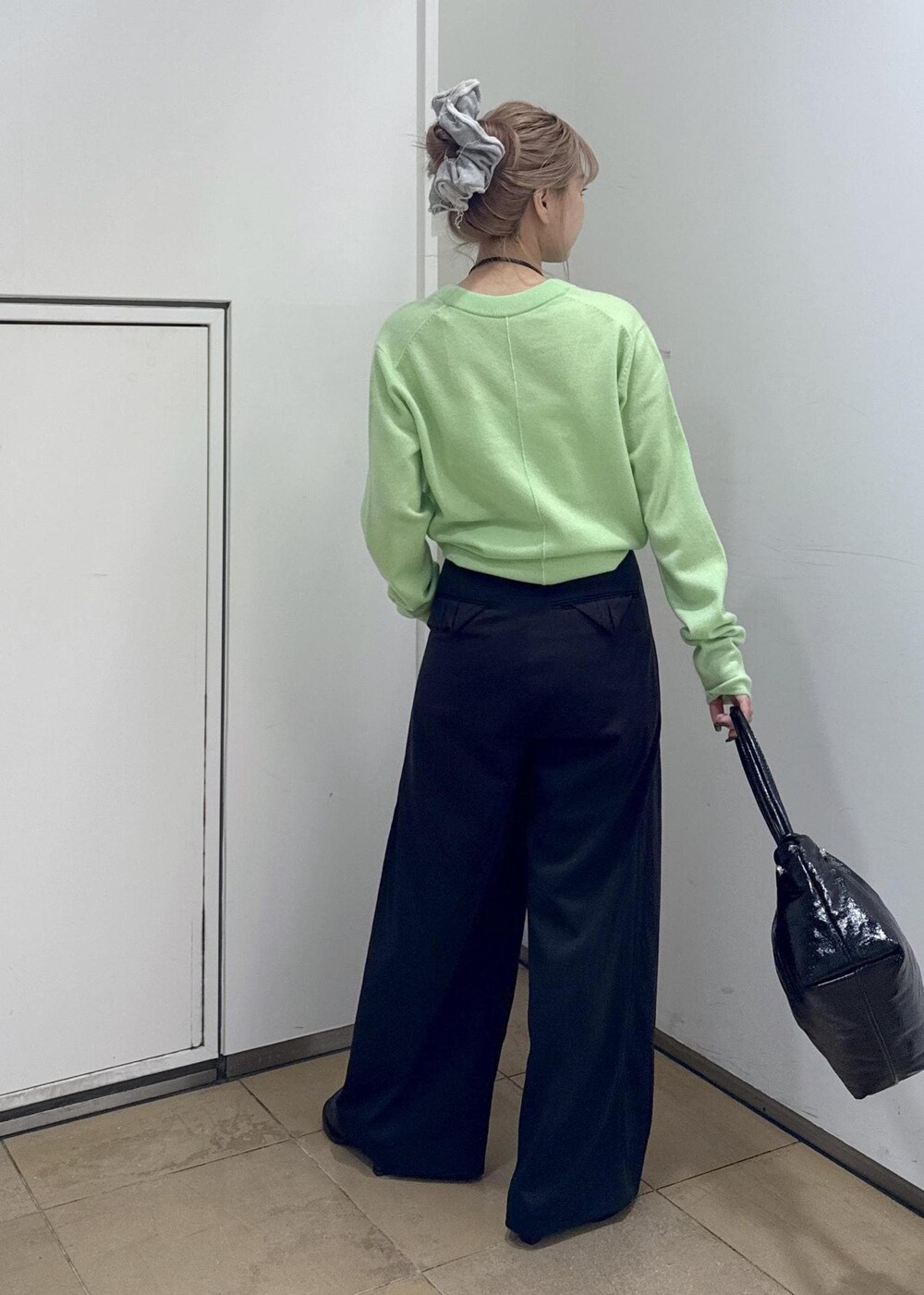 ブラック系のその他パンツ、ブラック系のサンダル、グリーン系のニット/セーターを着用したレディースの秋コーディネートの6枚目の写真