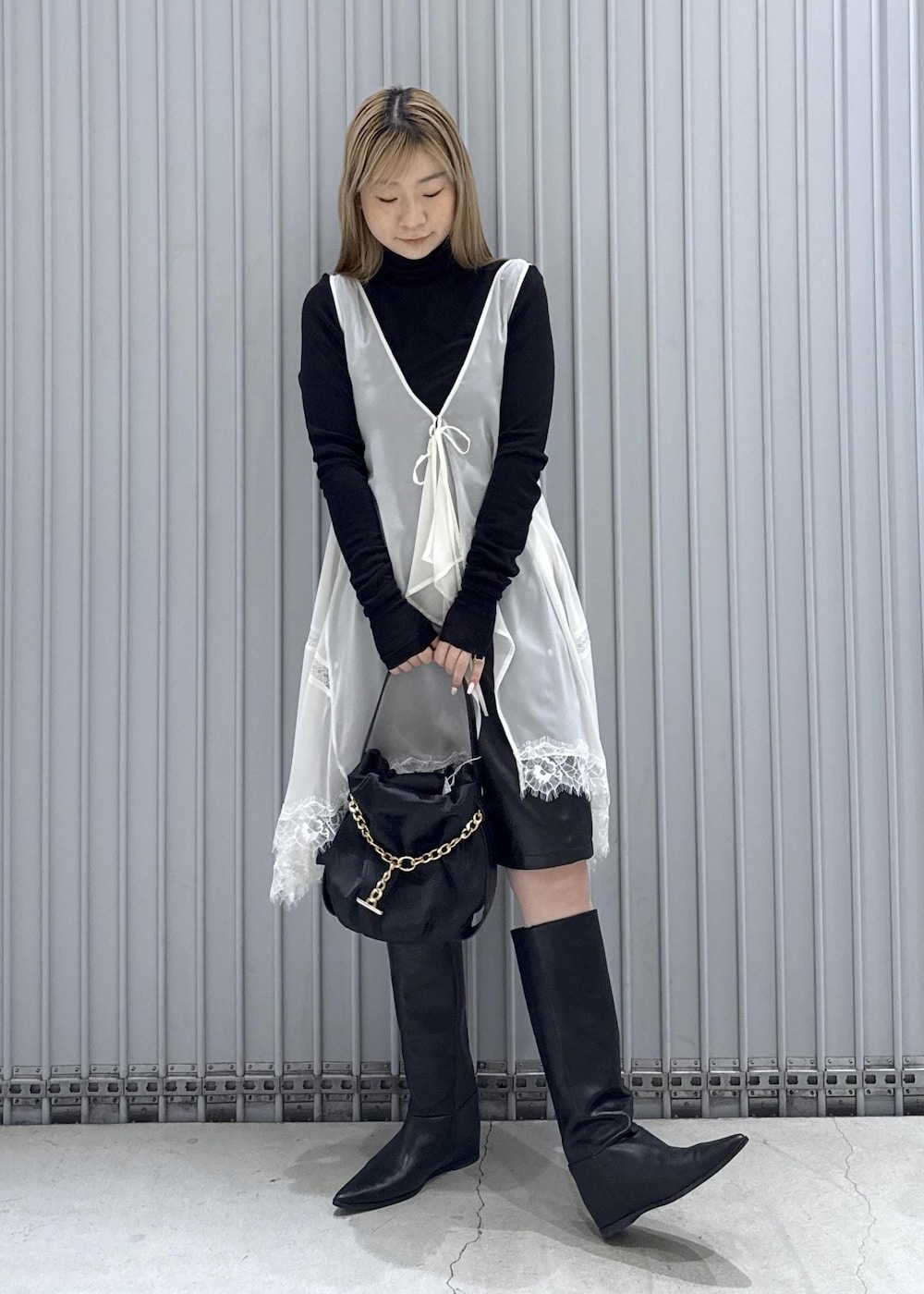 ブラック系のTシャツ/カットソー、ブラック系のブーツ、ブラック系のハンドバッグを着用したレディースの秋コーディネートの4枚目の写真