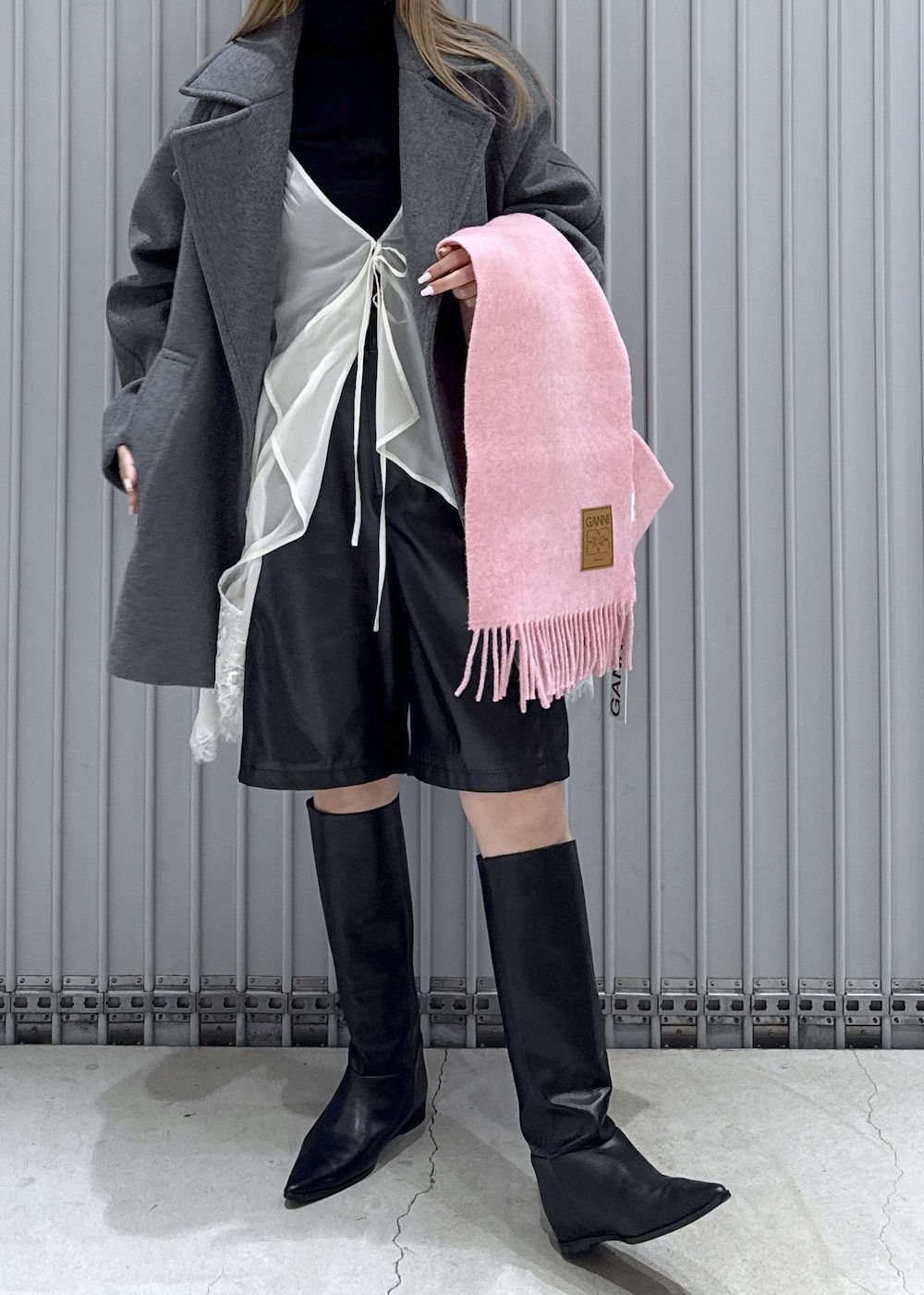 ブラック系のTシャツ/カットソー、ブラック系のブーツ、グレー系のステンカラーコートを着用したレディースの秋コーディネートの5枚目の写真