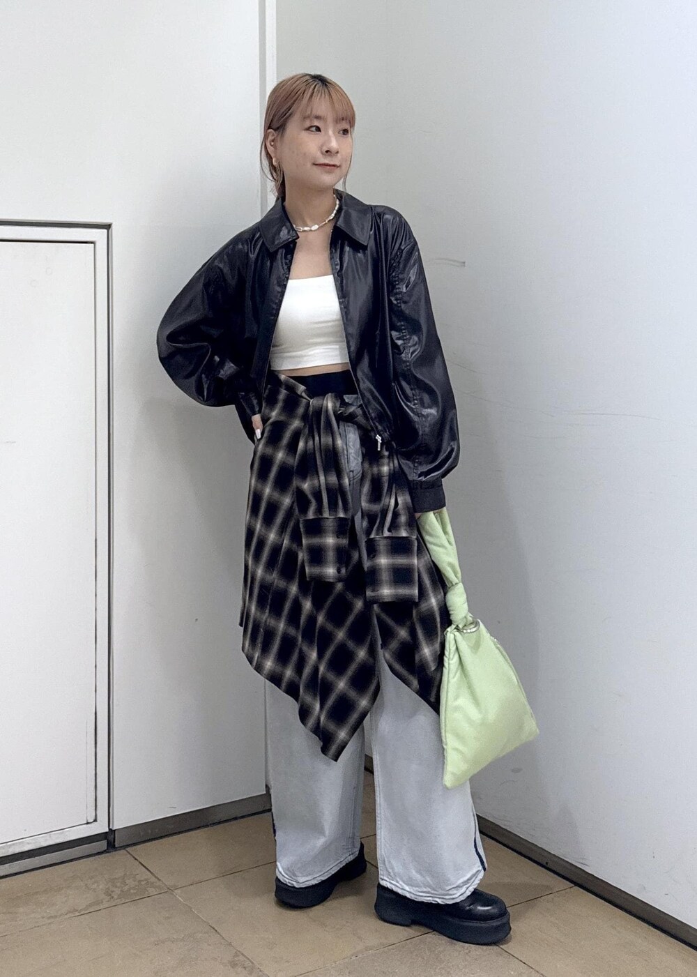 ブルー系のデニムパンツ、ブラック系のサンダル、グリーン系のハンドバッグを着用したレディースの秋コーディネートの4枚目の写真