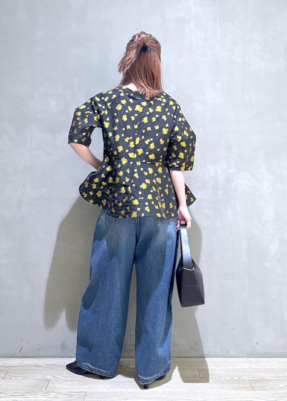 ブルー系のデニムパンツ、ブラック系のサンダル、ブラック系のショルダーバッグを着用したレディースの冬コーディネートの4枚目の写真