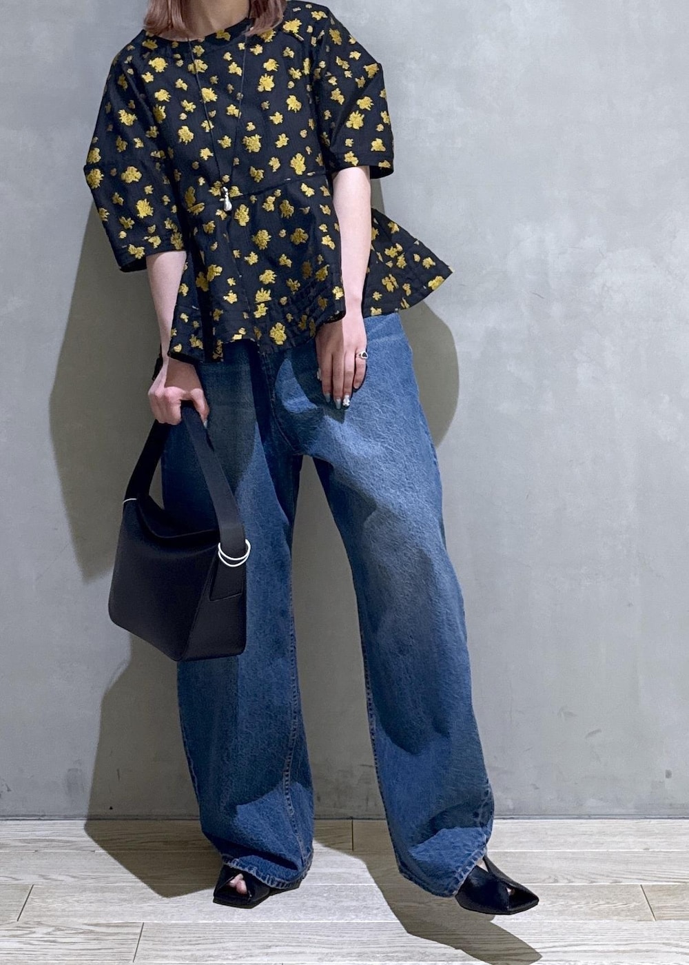 ブルー系のデニムパンツ、ブラック系のサンダル、ブラック系のショルダーバッグを着用したレディースの冬コーディネートの6枚目の写真