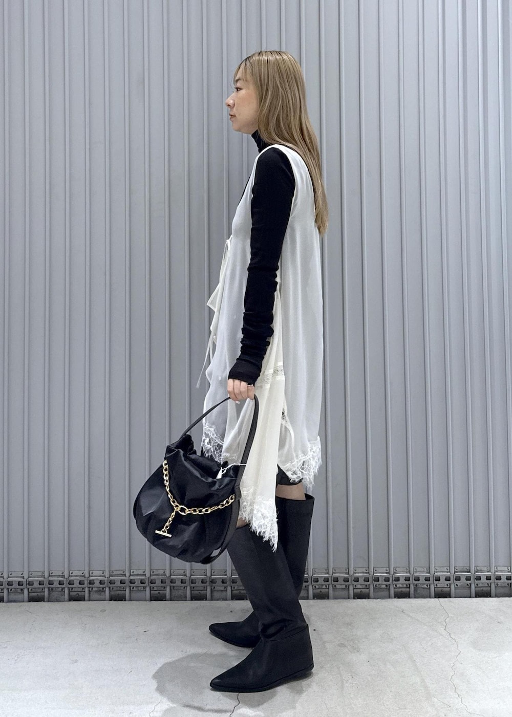 ブラック系のTシャツ/カットソー、ブラック系のブーツ、ブラック系のハンドバッグを着用したレディースの秋コーディネートの3枚目の写真