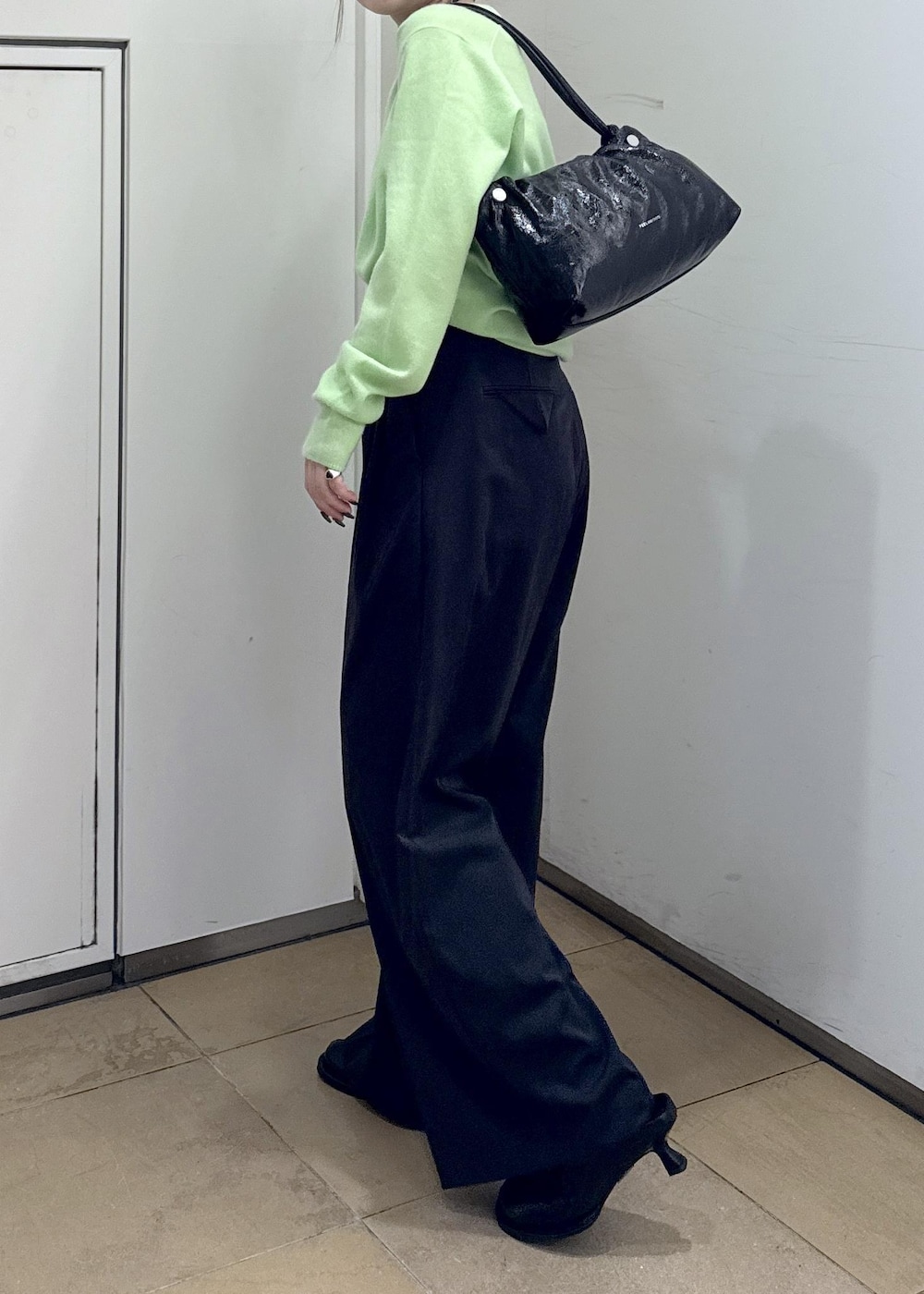 ブラック系のその他パンツ、ブラック系のサンダル、グリーン系のニット/セーターを着用したレディースの秋コーディネートの7枚目の写真