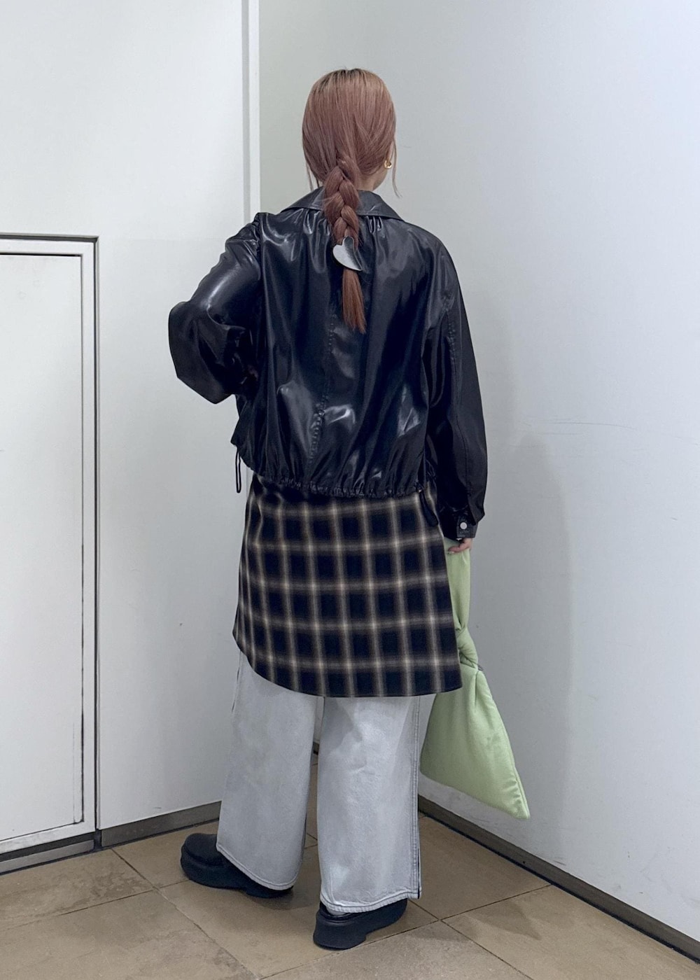 ブルー系のデニムパンツ、ブラック系のサンダル、グリーン系のハンドバッグを着用したレディースの秋コーディネートの5枚目の写真