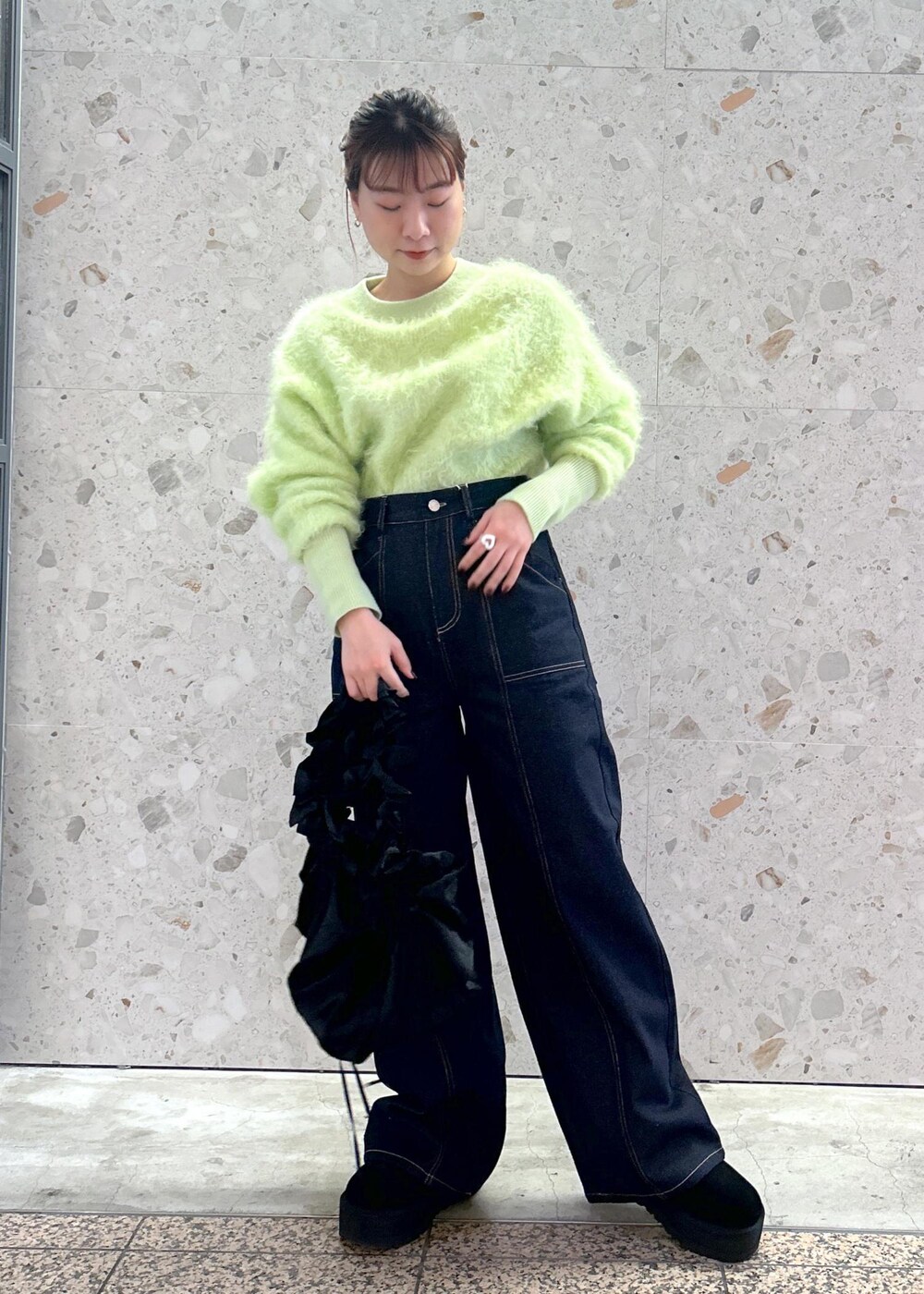 グリーン系のニット/セーター、ブルー系のデニムパンツを着用したレディースの秋コーディネートの3枚目の写真