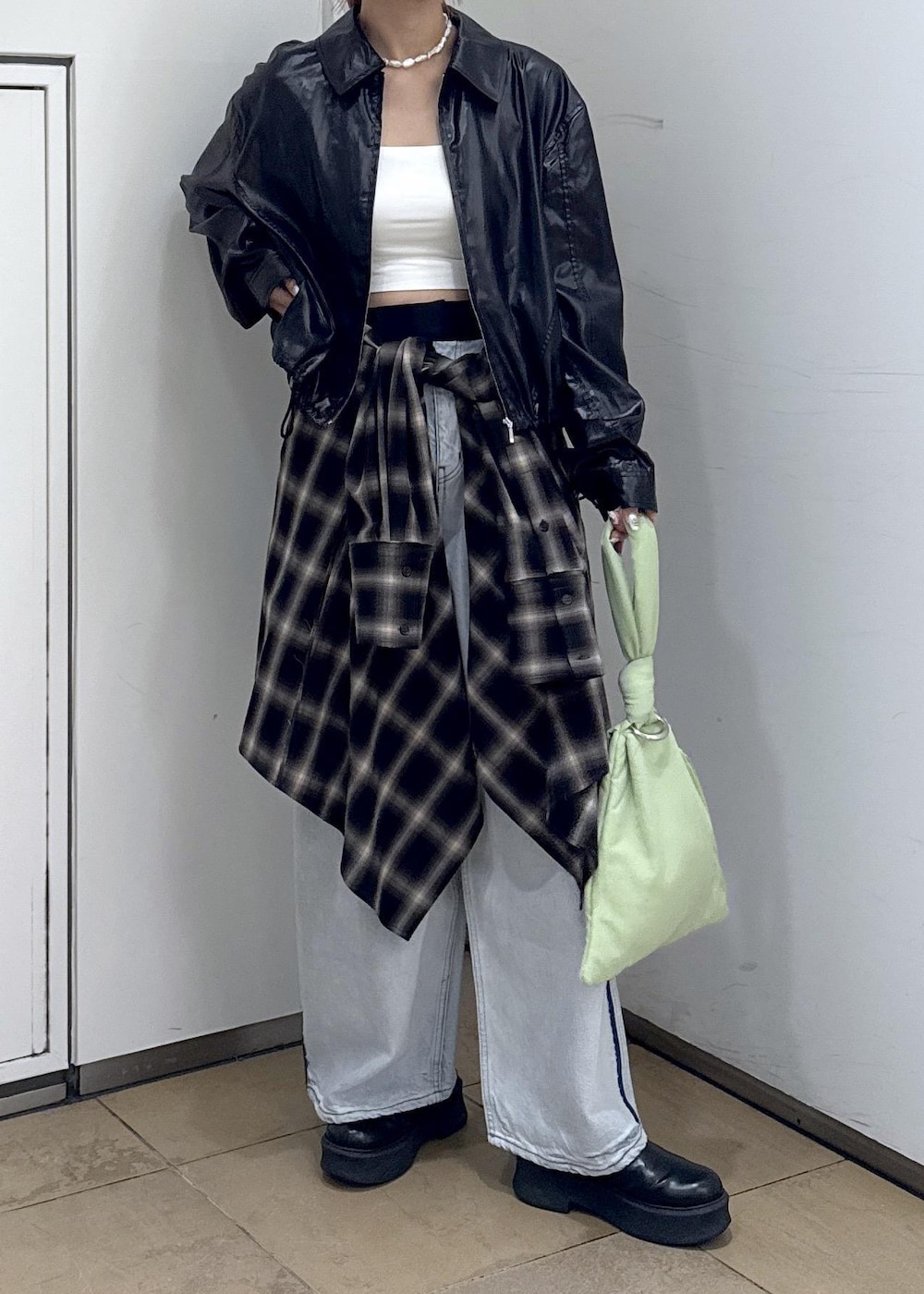 ブルー系のデニムパンツ、ブラック系のサンダル、グリーン系のハンドバッグを着用したレディースの秋コーディネートの7枚目の写真