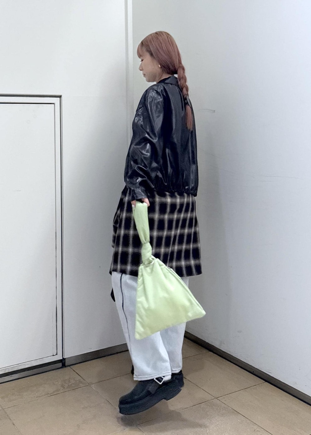 ブルー系のデニムパンツ、ブラック系のサンダル、グリーン系のハンドバッグを着用したレディースの秋コーディネートの3枚目の写真