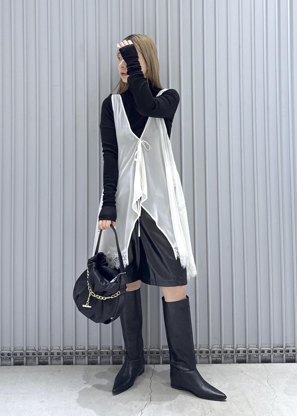 ブラック系のTシャツ/カットソー、ブラック系のブーツ、ブラック系のハンドバッグを着用したレディースの秋コーディネートの2枚目の写真