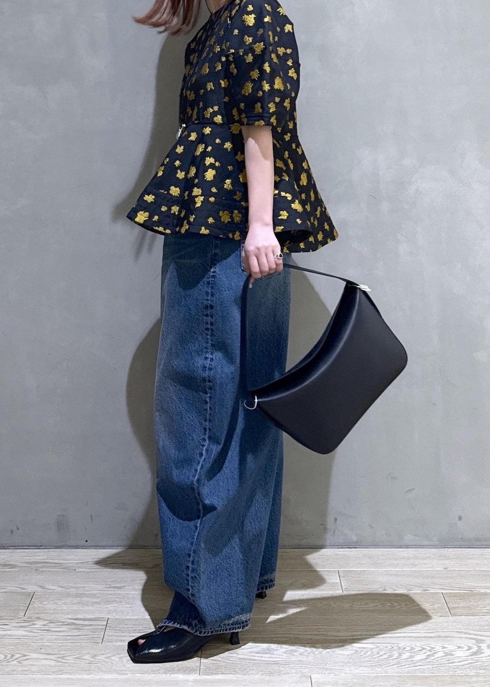 ブルー系のデニムパンツ、ブラック系のサンダル、ブラック系のショルダーバッグを着用したレディースの冬コーディネートの3枚目の写真