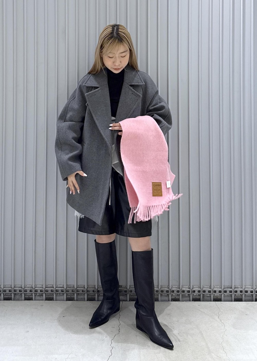 ブラック系のTシャツ/カットソー、ブラック系のブーツ、グレー系のステンカラーコートを着用したレディースの秋コーディネートの2枚目の写真