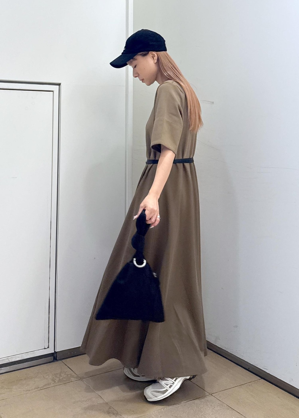 ブラウン系のワンピース、ブラック系のハンドバッグを着用したレディースの夏コーディネートの6枚目の写真