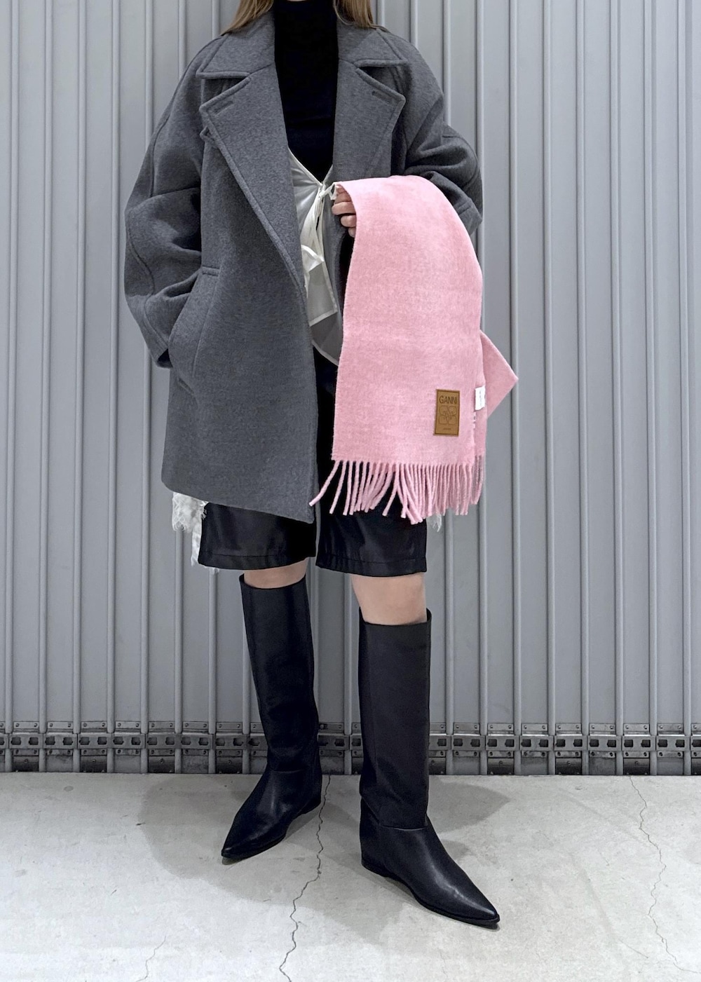 ブラック系のTシャツ/カットソー、ブラック系のブーツ、グレー系のステンカラーコートを着用したレディースの秋コーディネートの6枚目の写真