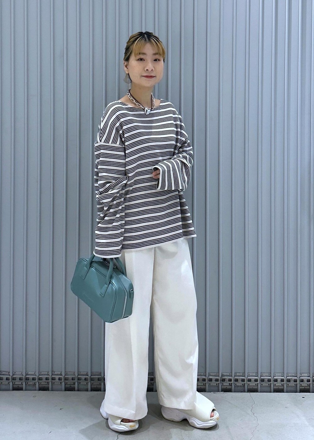 ホワイト系のサンダル、ホワイト系のその他パンツ、ブルー系のボストンバッグを着用したレディースの春コーディネートの4枚目の写真