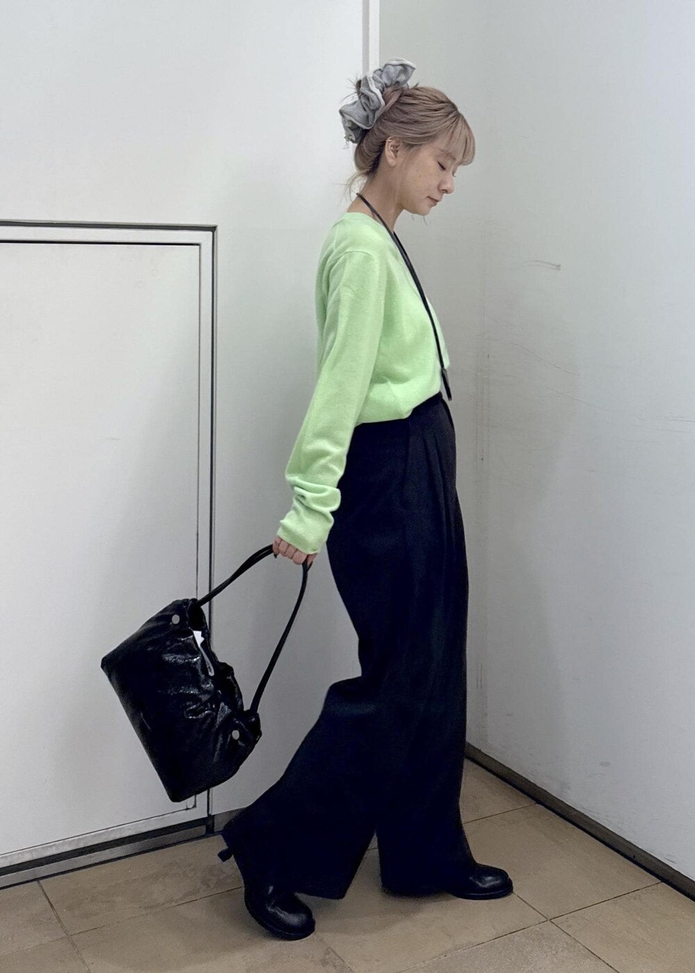 ブラック系のその他パンツ、ブラック系のサンダル、グリーン系のニット/セーターを着用したレディースの秋コーディネートの5枚目の写真